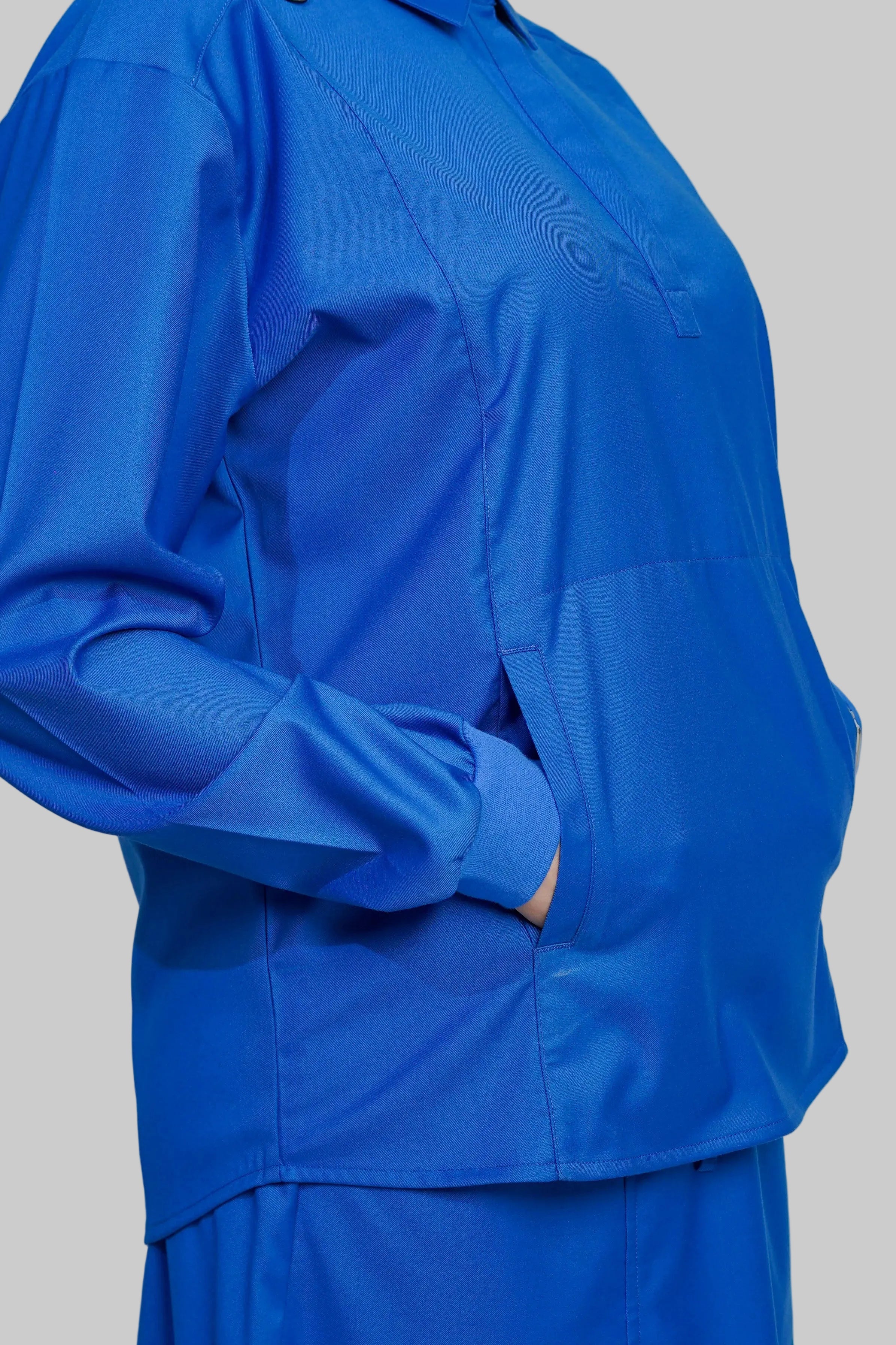 Blue outfit with a jacket and pants on a gray background