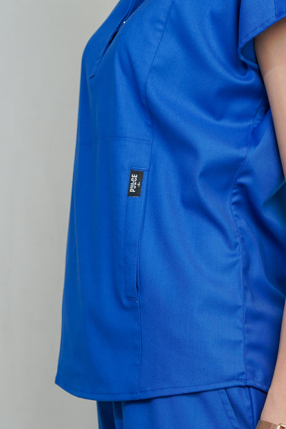 Blue scrub top with a brand logo on a plain background
