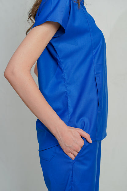 Person wearing a blue scrub set against a plain background