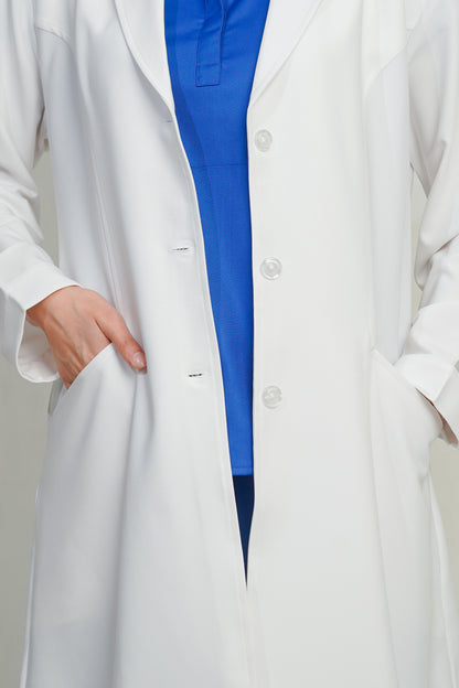 Person wearing a white lab coat over a blue shirt on a plain background