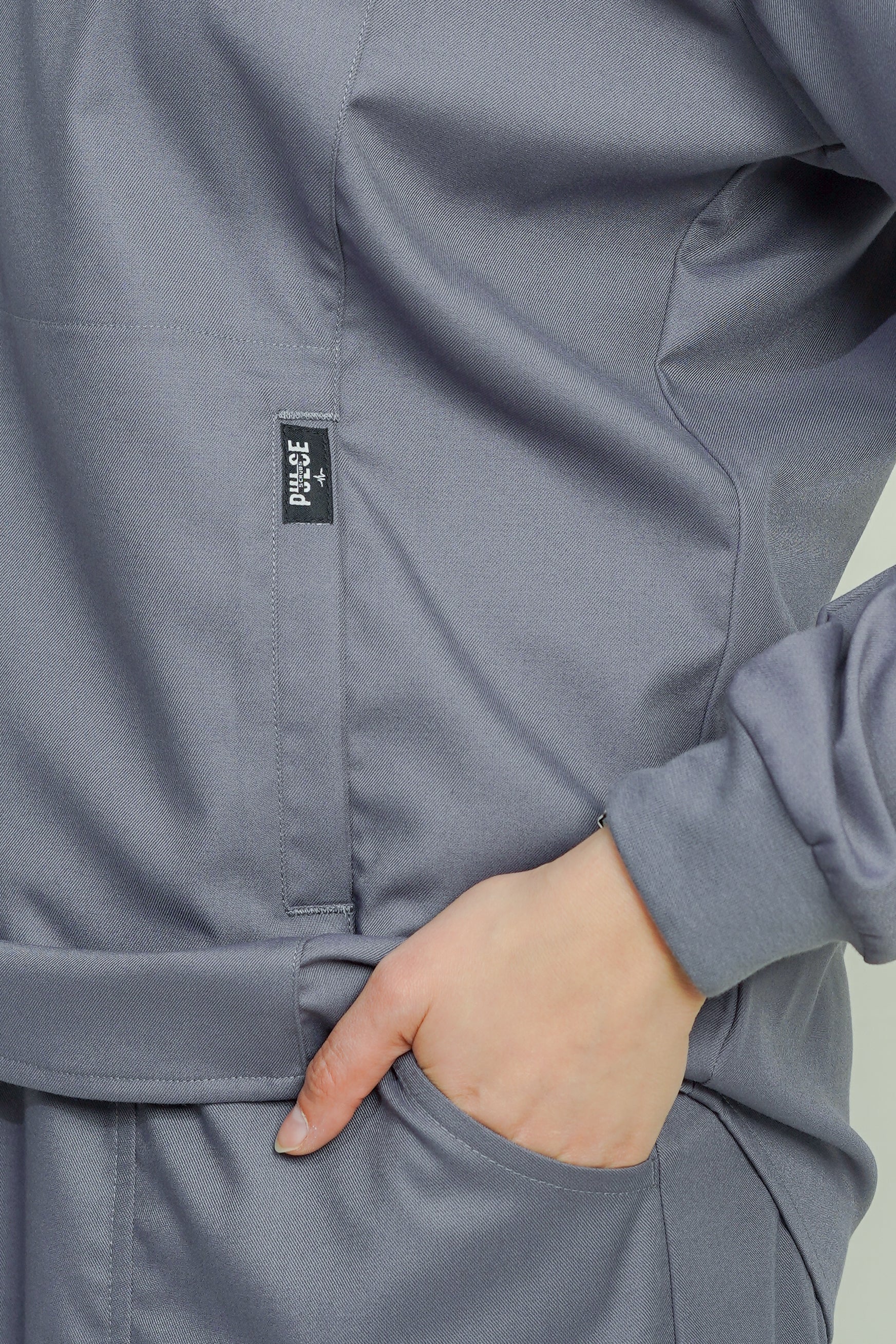 Gray jacket with a brand label on a light green background