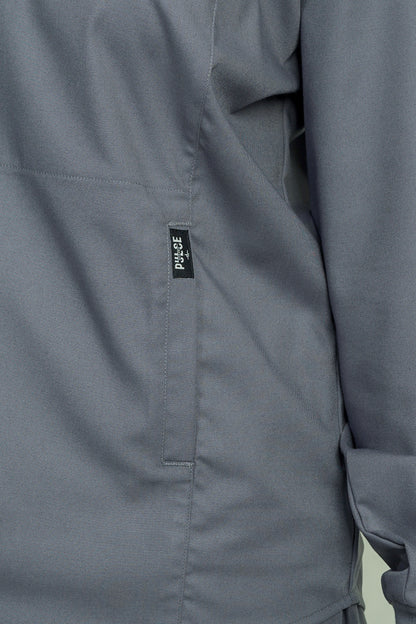 Close-up of a gray jacket with a visible brand label on a light green background