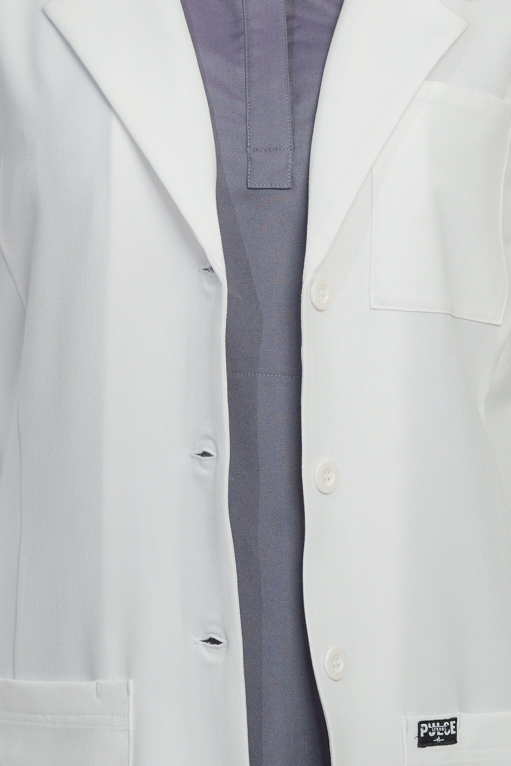 Close-up of a white lab coat with a visible brand logo on a white background