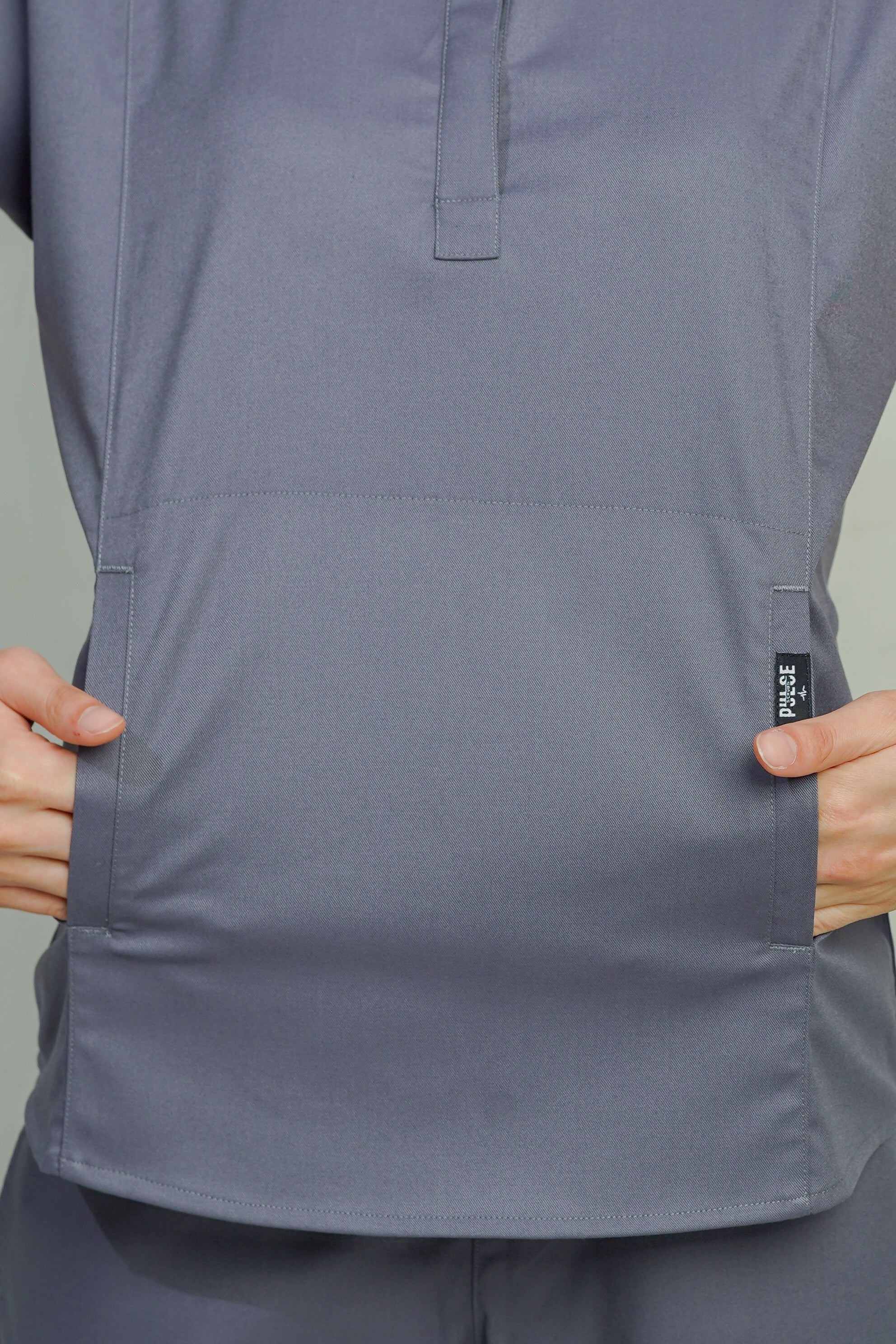 Gray short-sleeve shirt with a brand label on a plain background