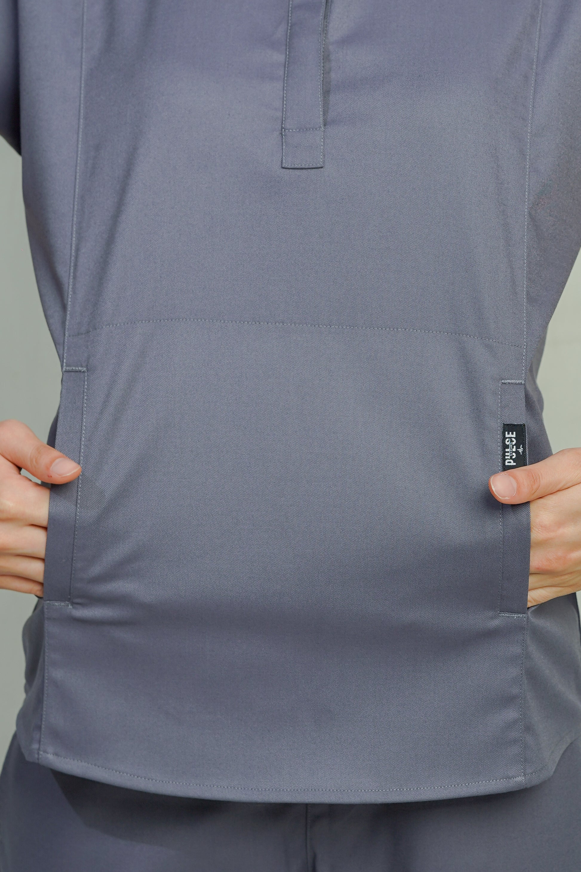 Gray short-sleeve shirt with a brand label on a plain background