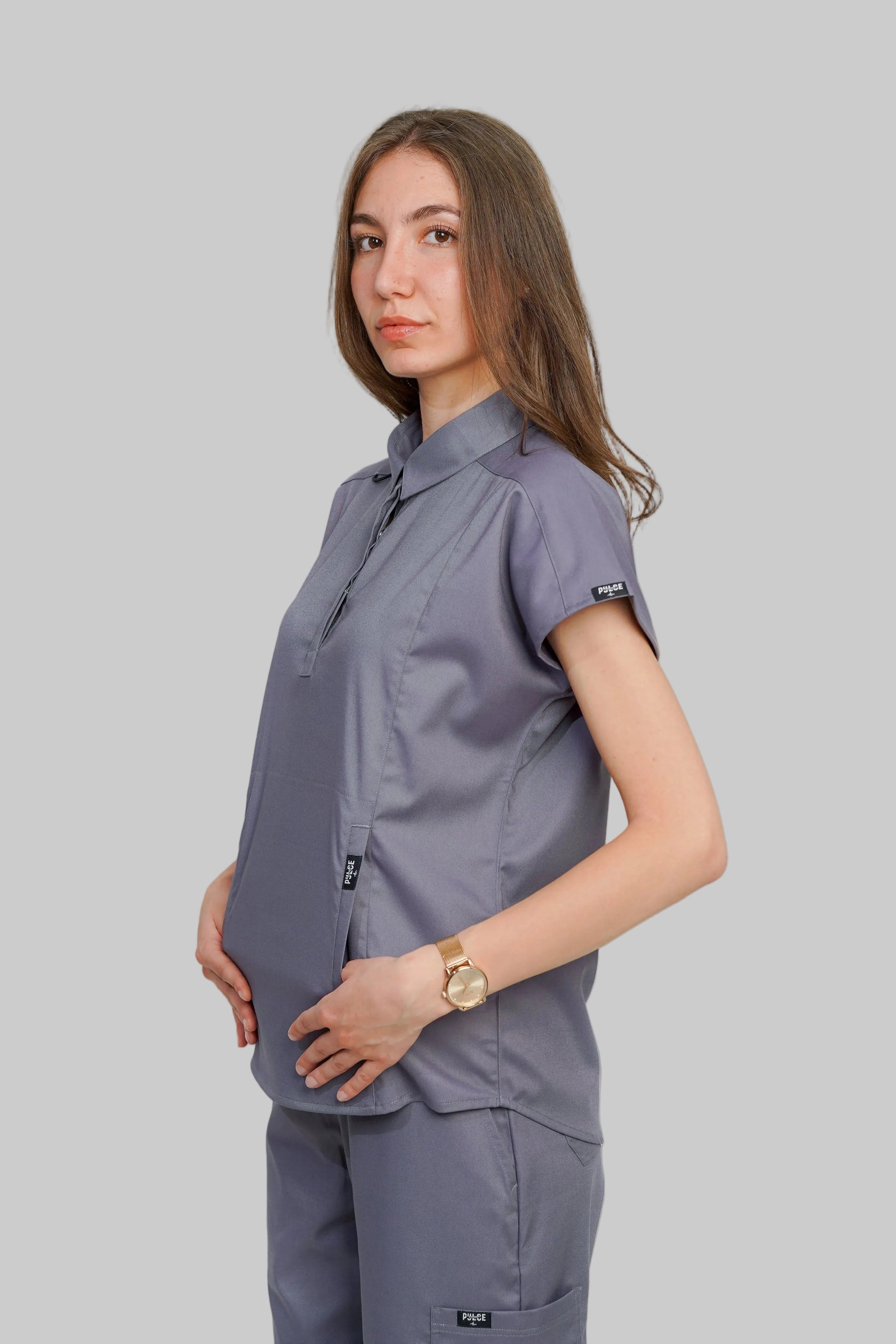 Woman wearing a gray uniform against a white background