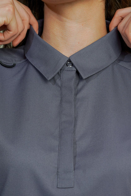 Close-up of a person adjusting the collar of a dark gray shirt.