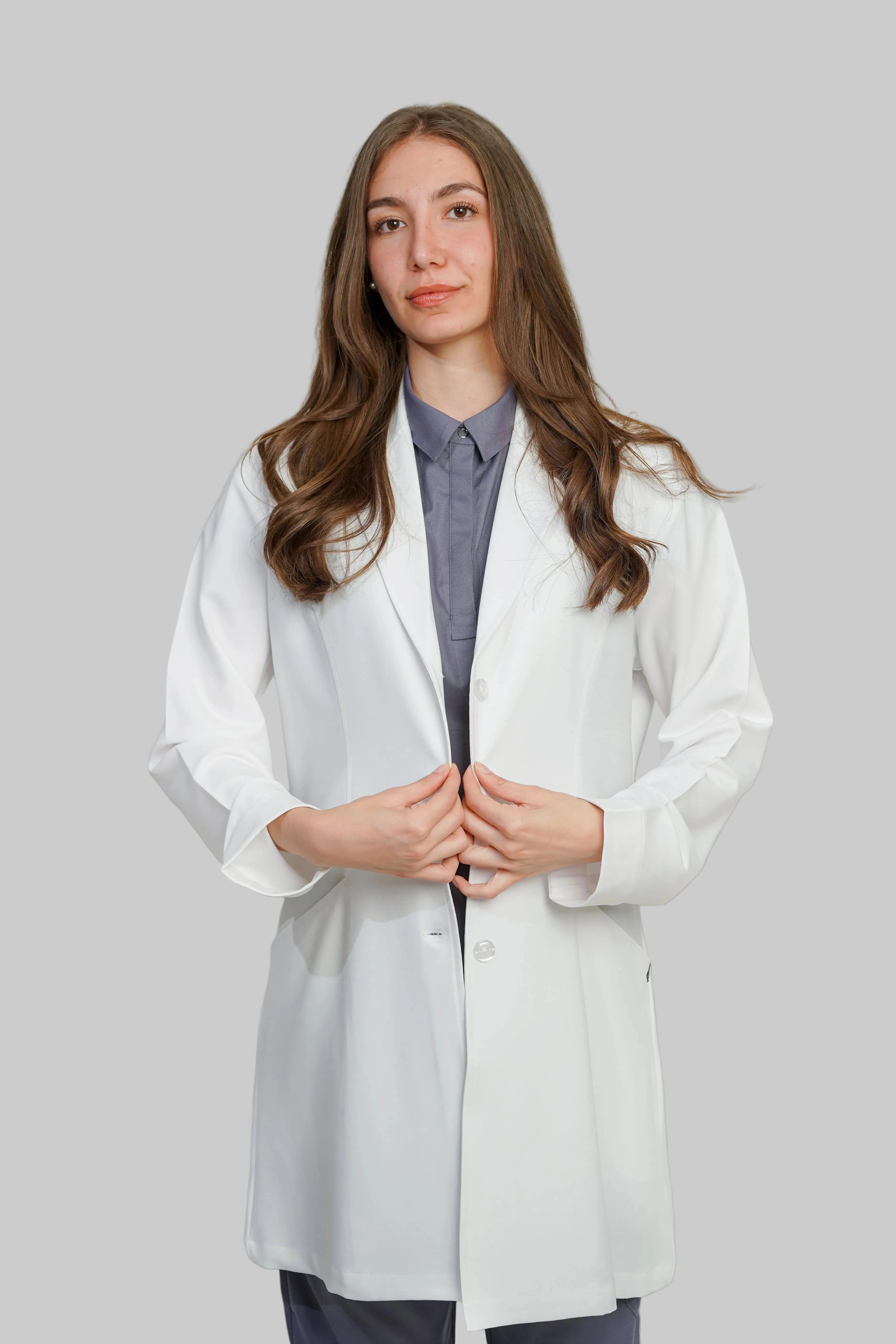 Person wearing a white lab coat against a plain background