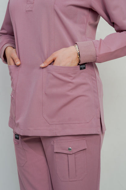 Person wearing a pink scrub set with a plain background