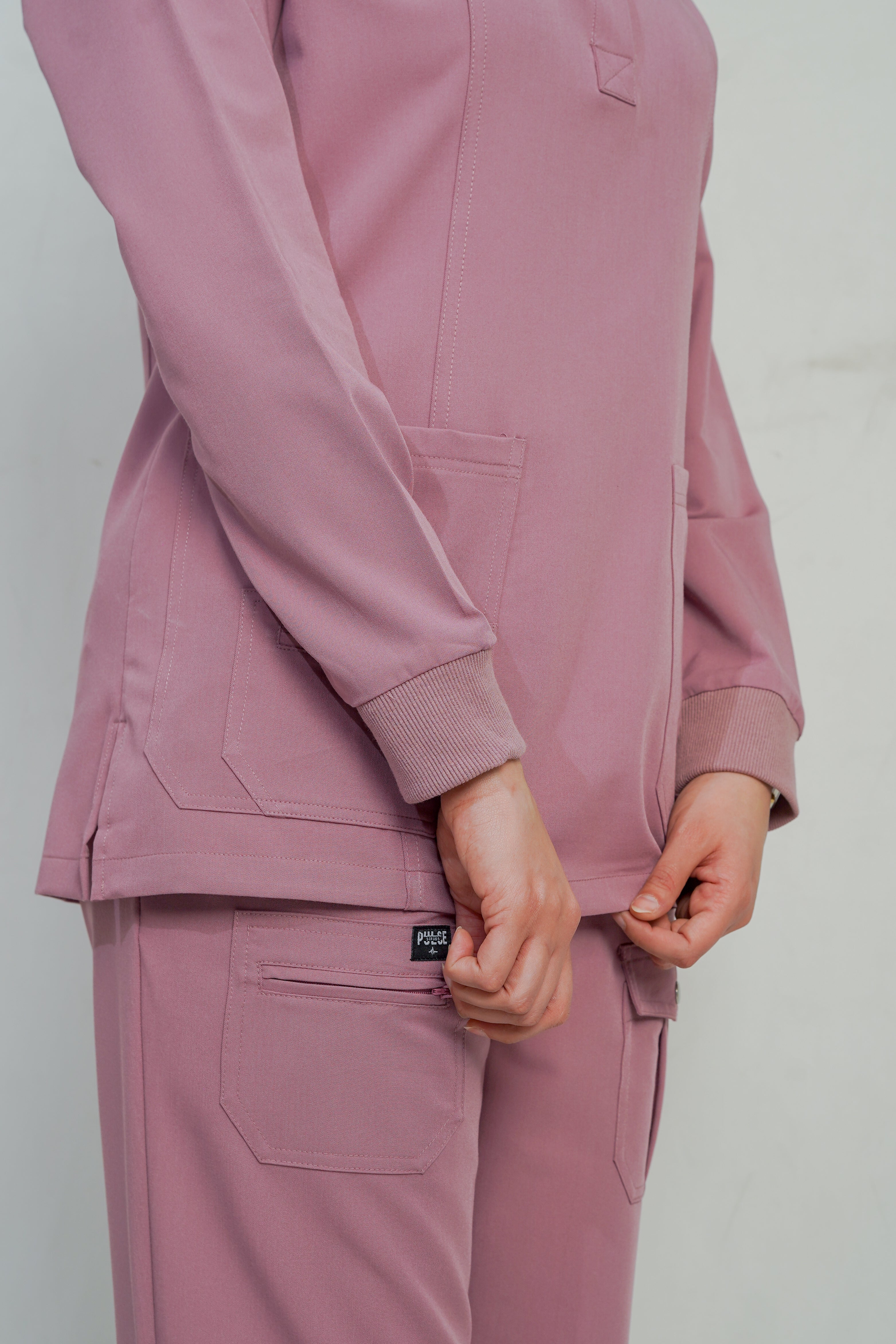 Person wearing a pink tracksuit against a plain background