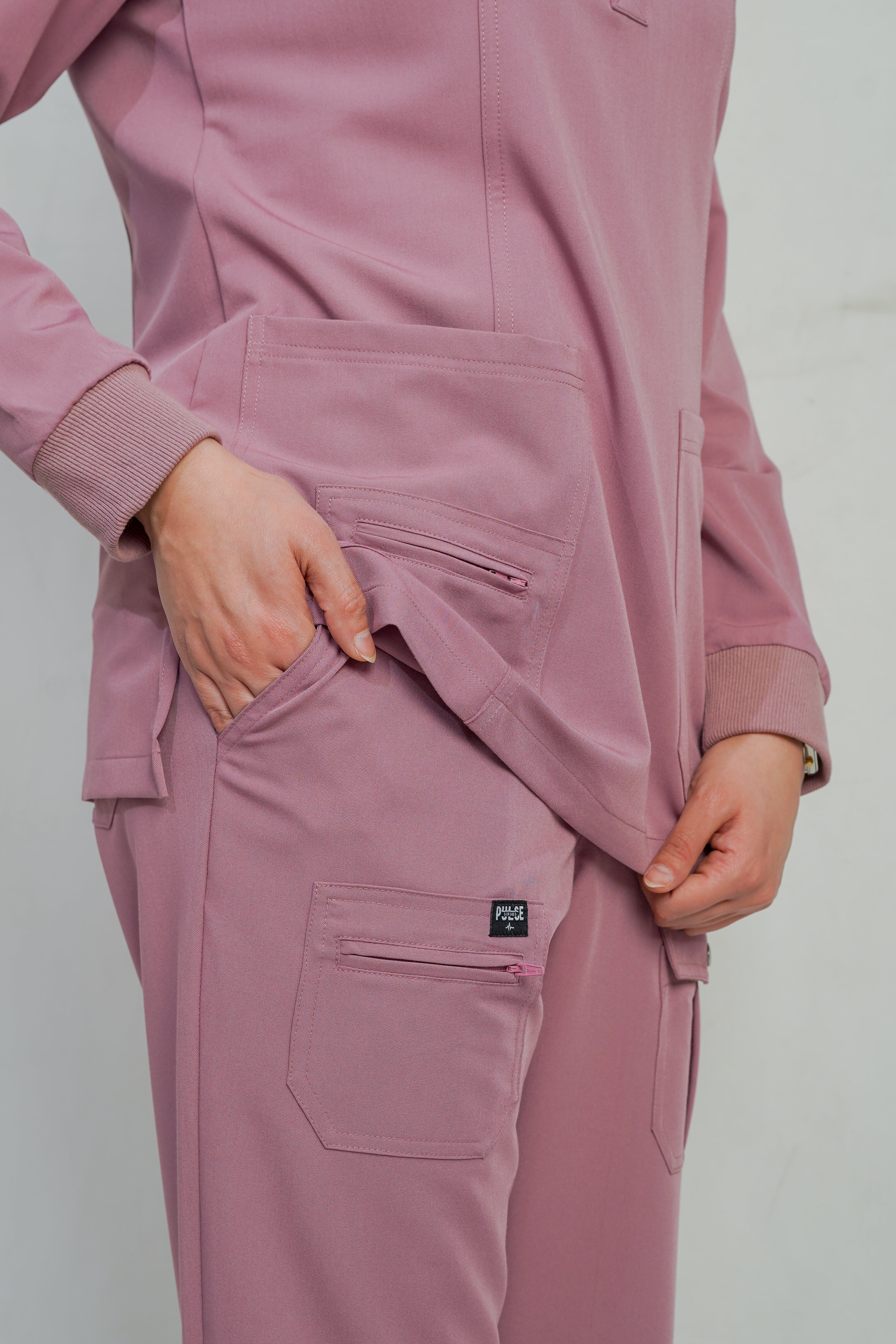 Pink tracksuit with a brand logo on a plain background