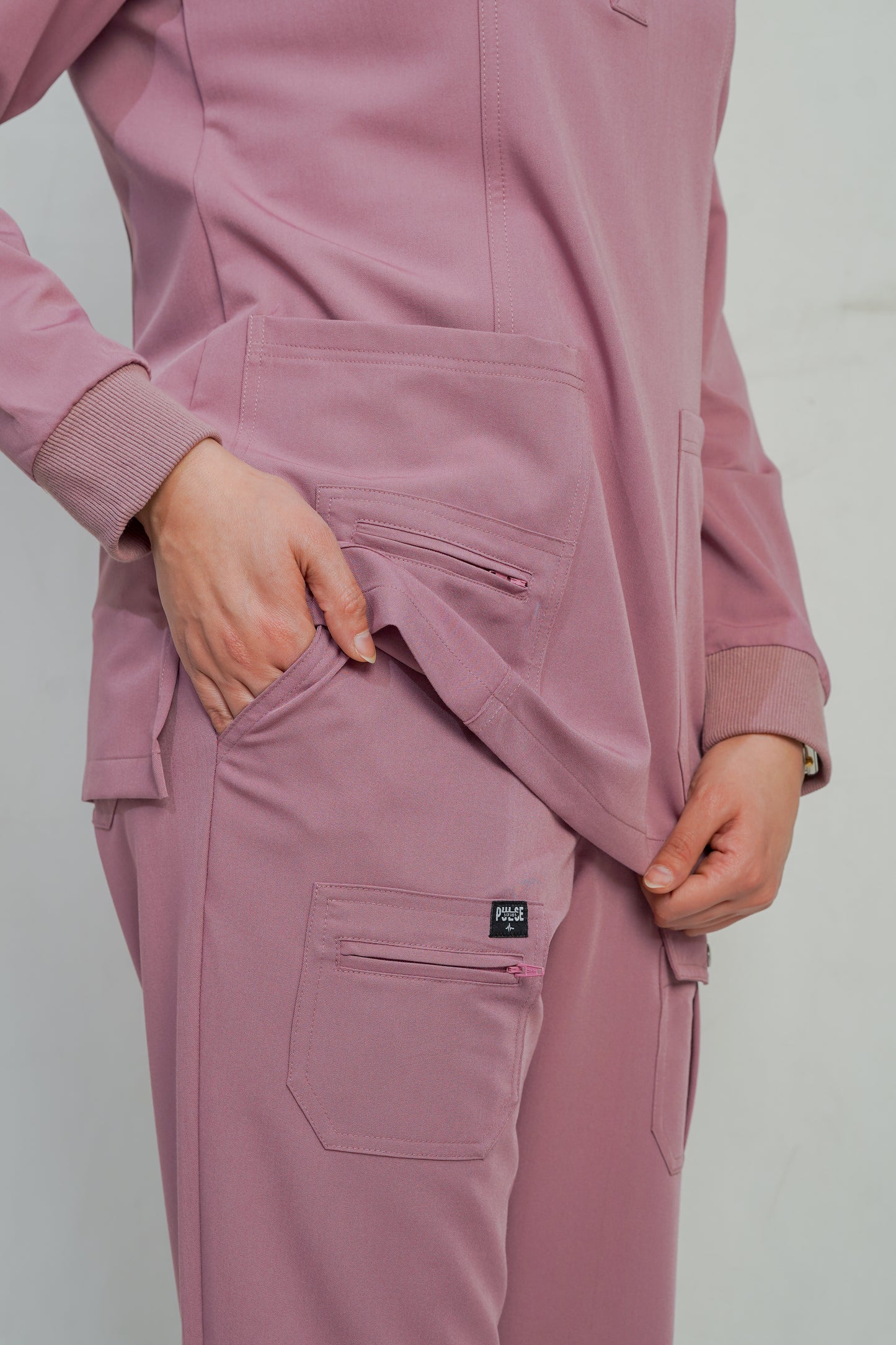 Pink tracksuit with a brand logo on a plain background
