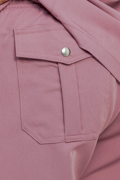 Close-up of a pink jacket with a button on a matching fabric background