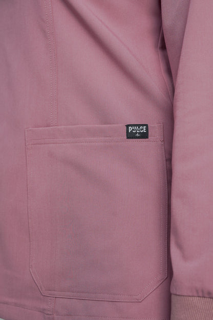 Close-up of a pink jacket with a brand label on the chest pocket.