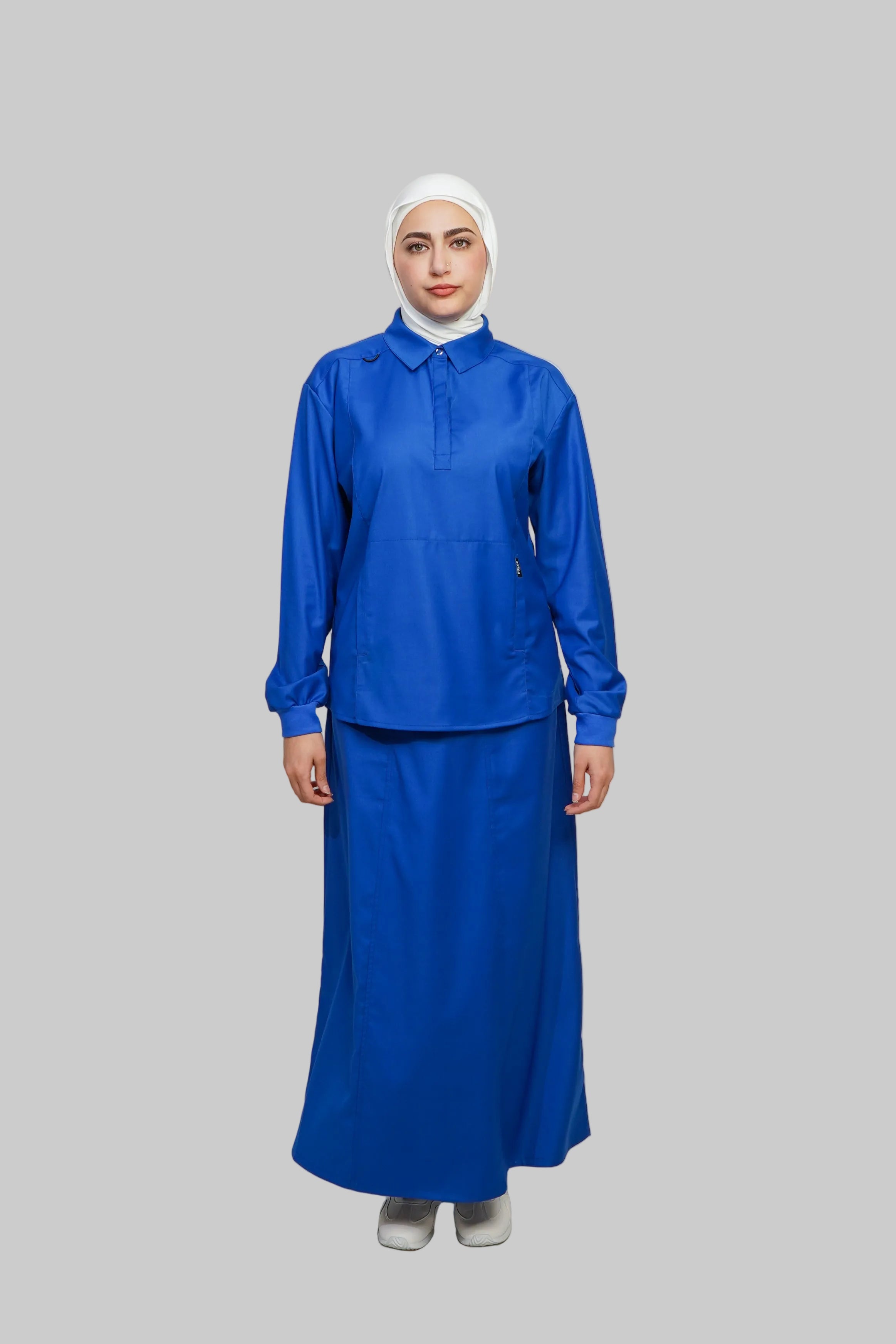 Person wearing a blue outfit with a white hijab on a gray background