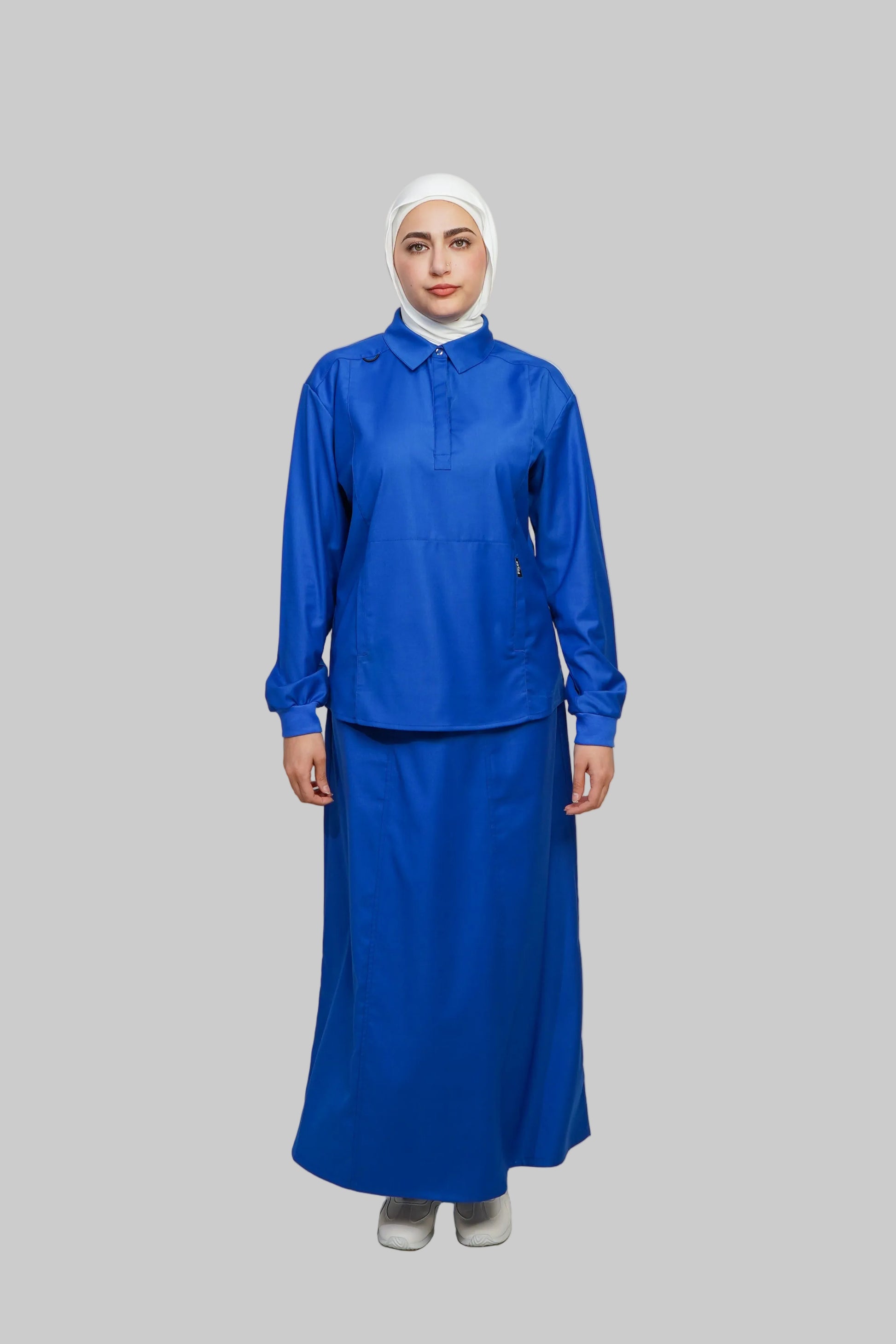 Person wearing a blue outfit with a white hijab on a gray background