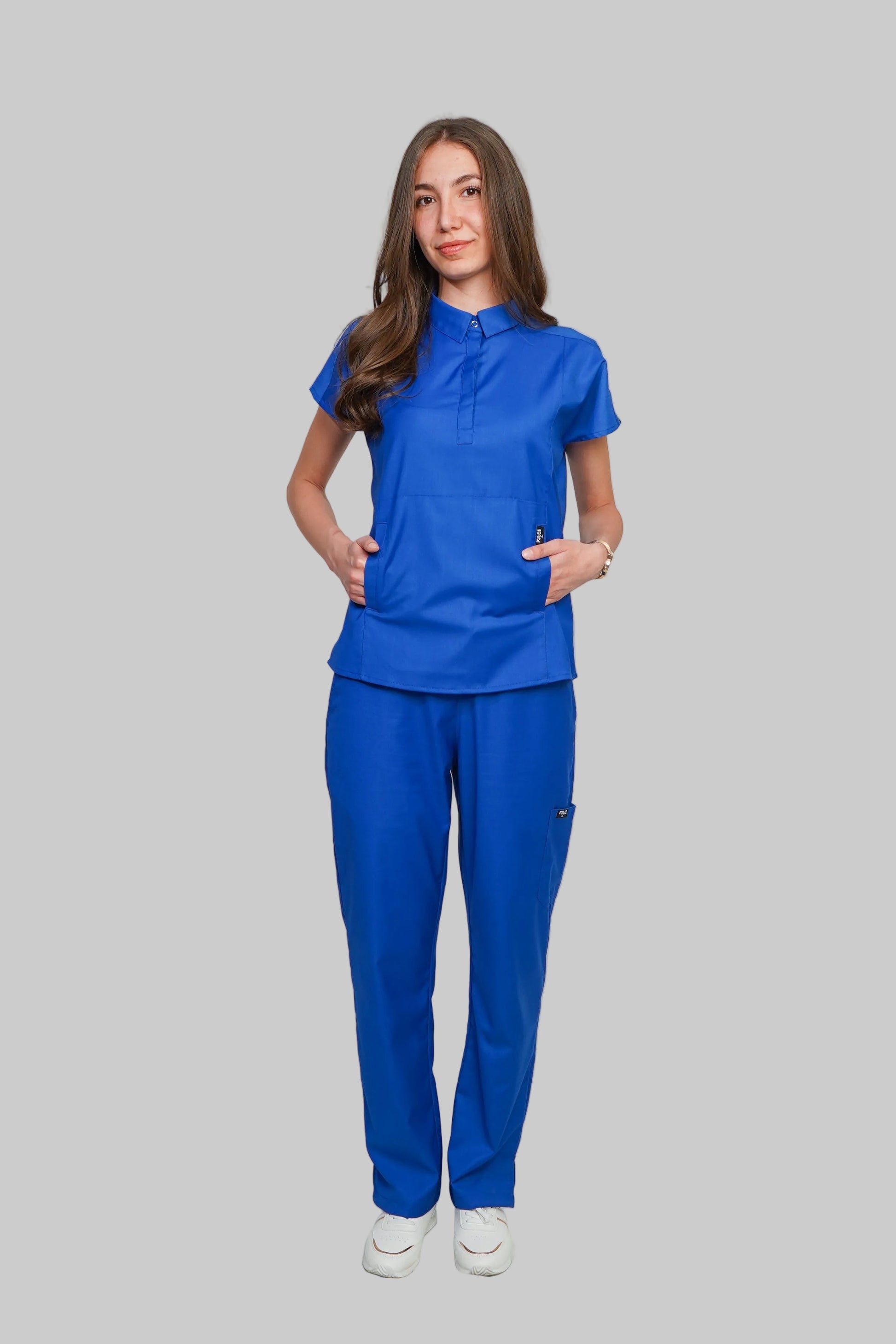 Person wearing a blue scrub set against a plain background