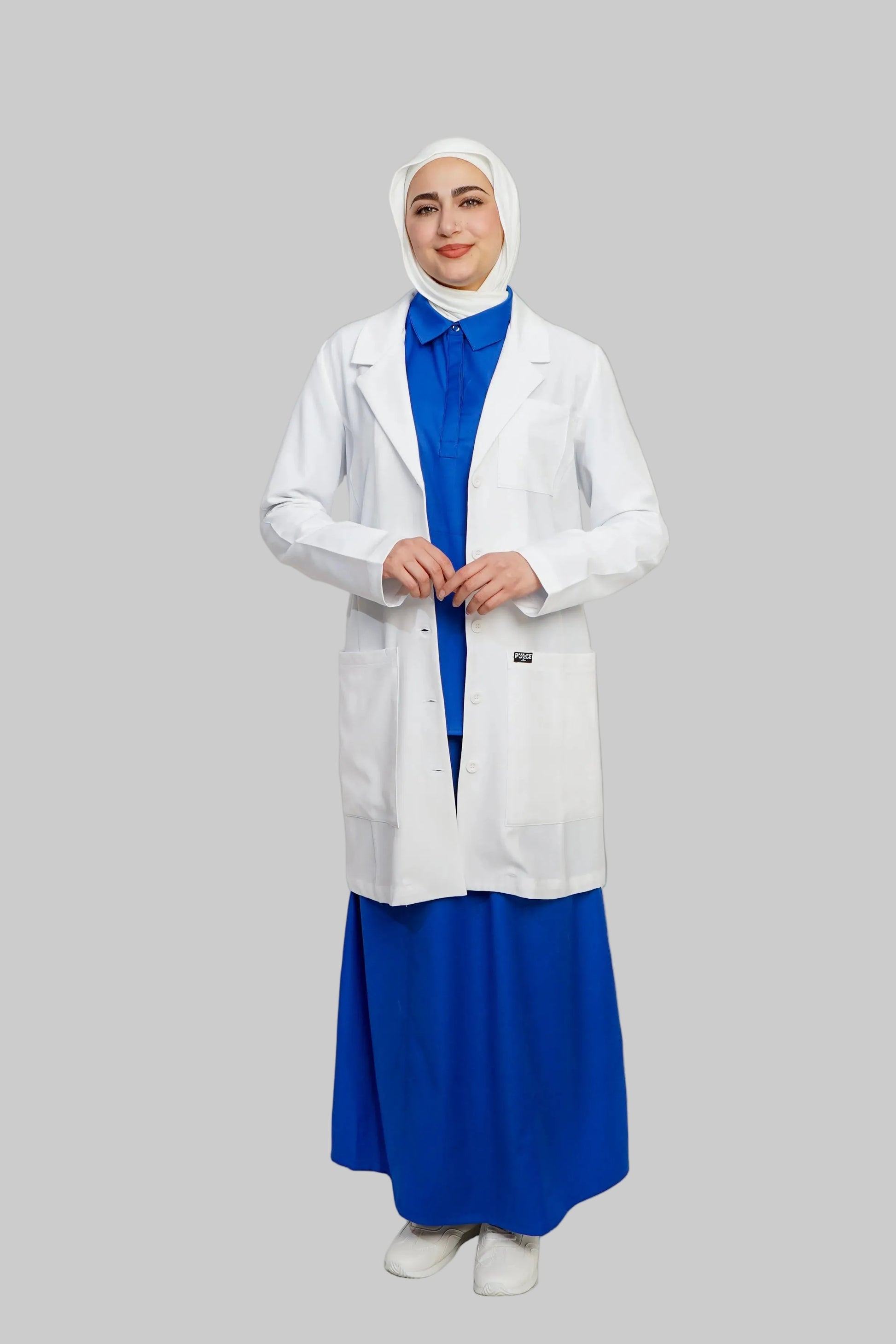 Person wearing a white lab coat over a blue dress on a plain background