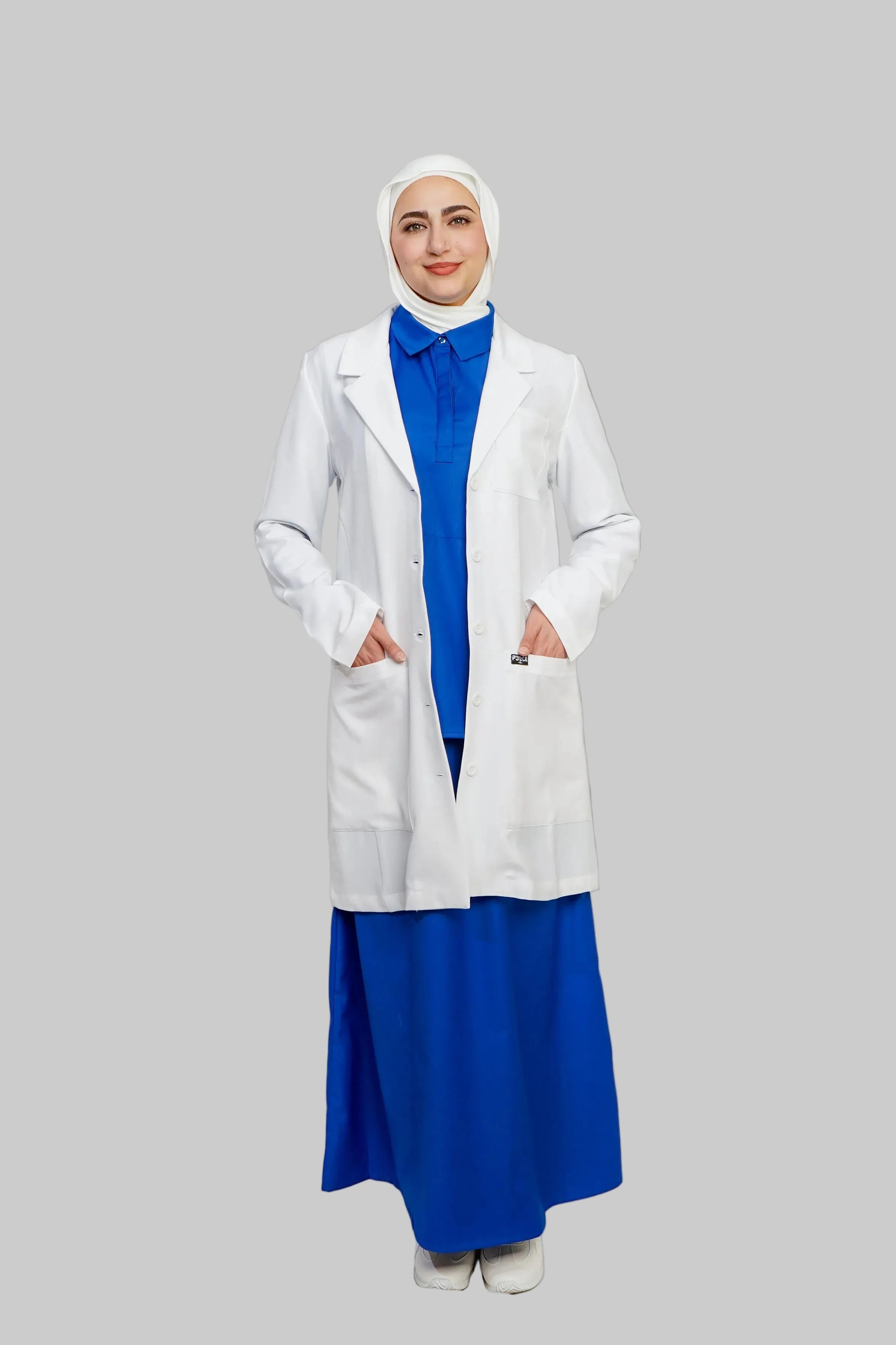 Person wearing a white lab coat over a blue outfit on a plain background