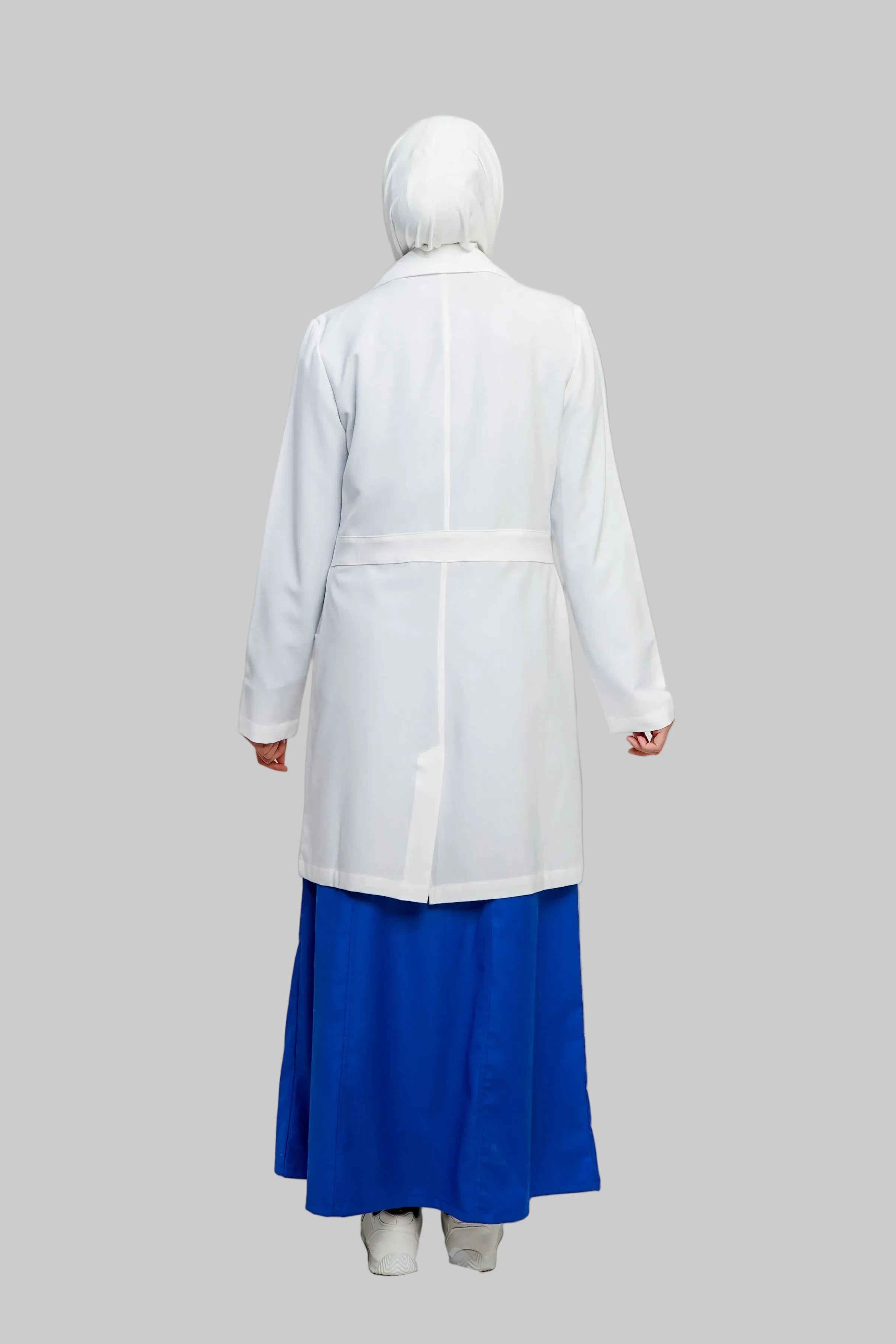 Person wearing a white lab coat over a blue skirt on a plain background