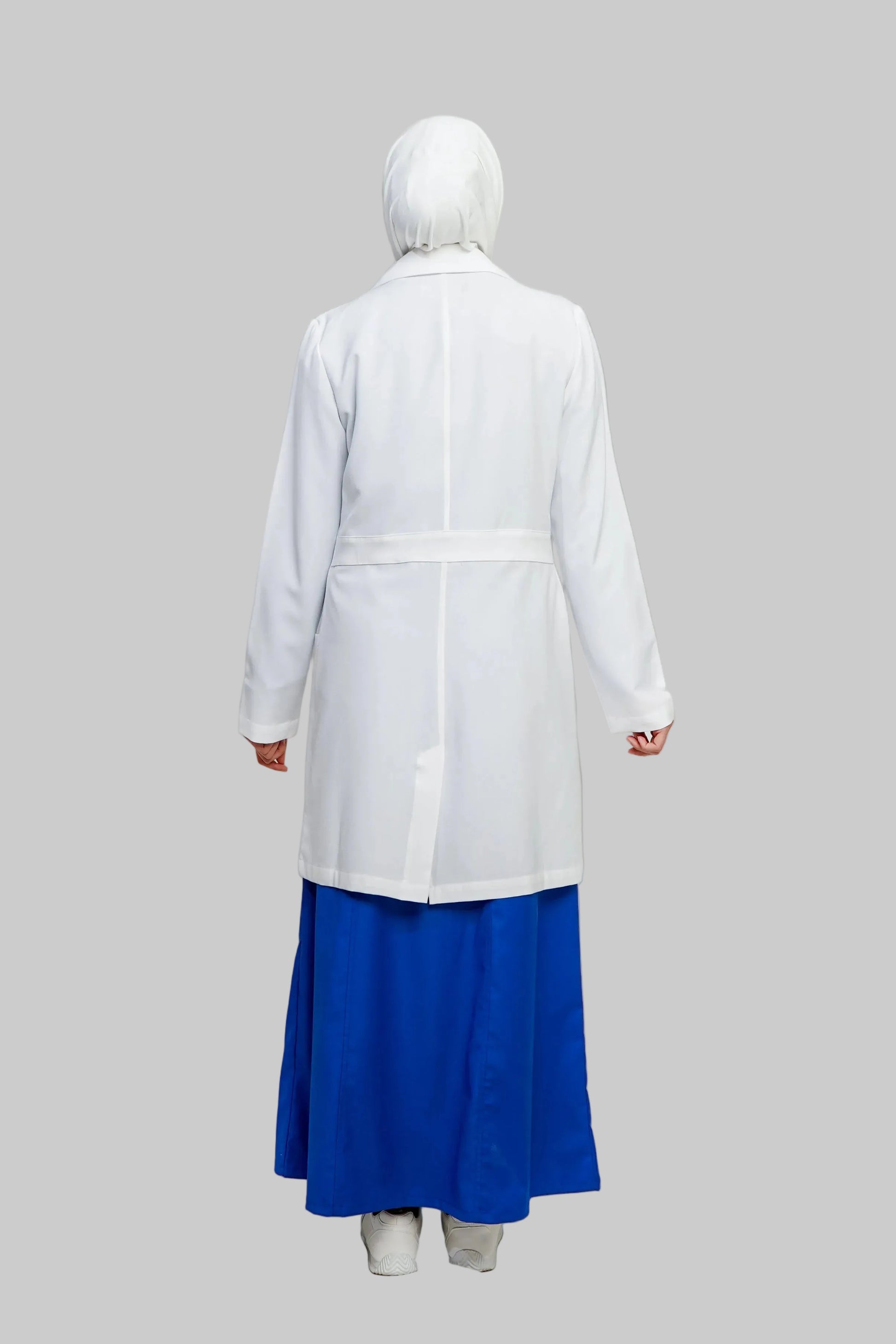 Person wearing a white lab coat over a blue skirt on a plain background