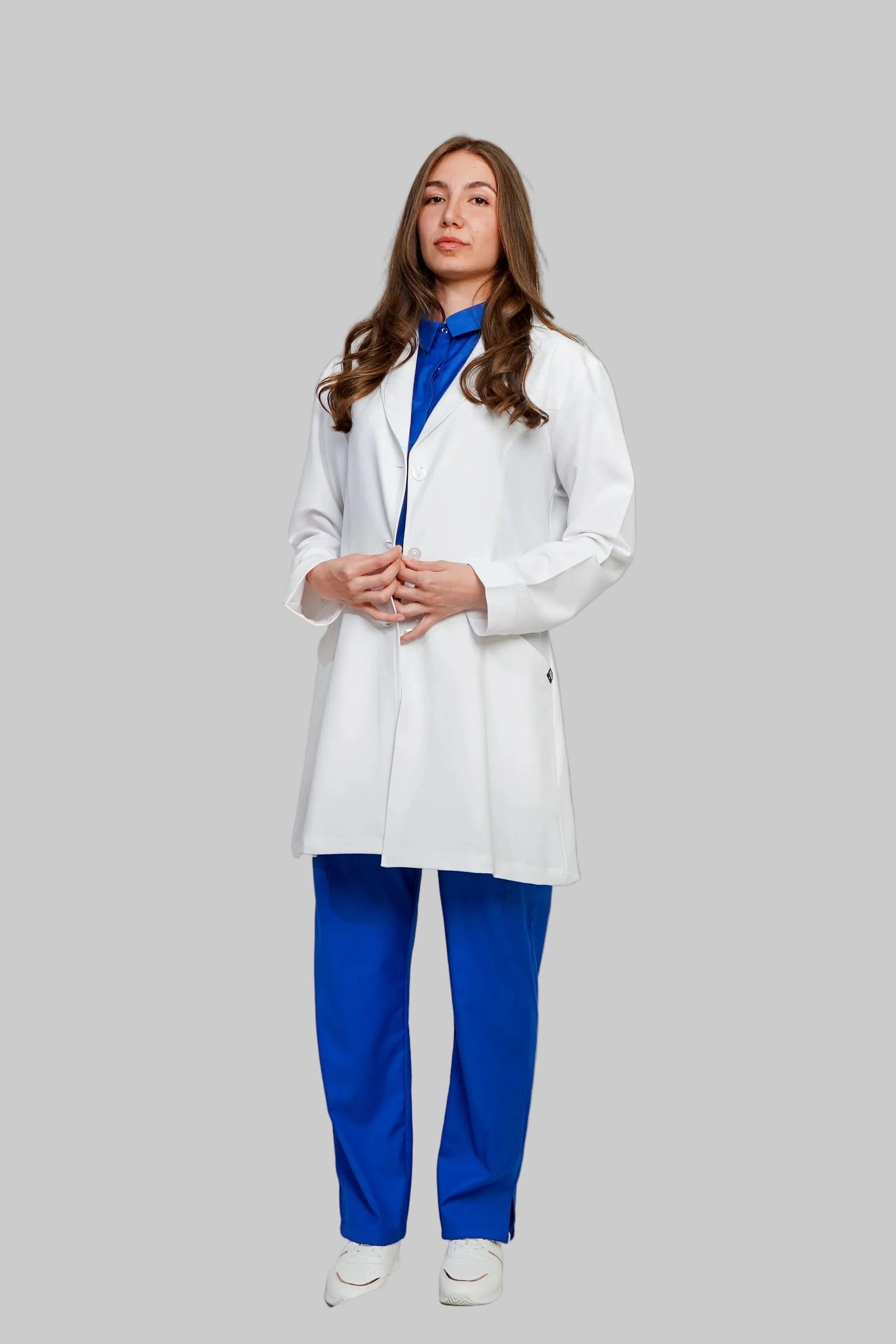 Person wearing a white lab coat over a blue outfit on a plain background
