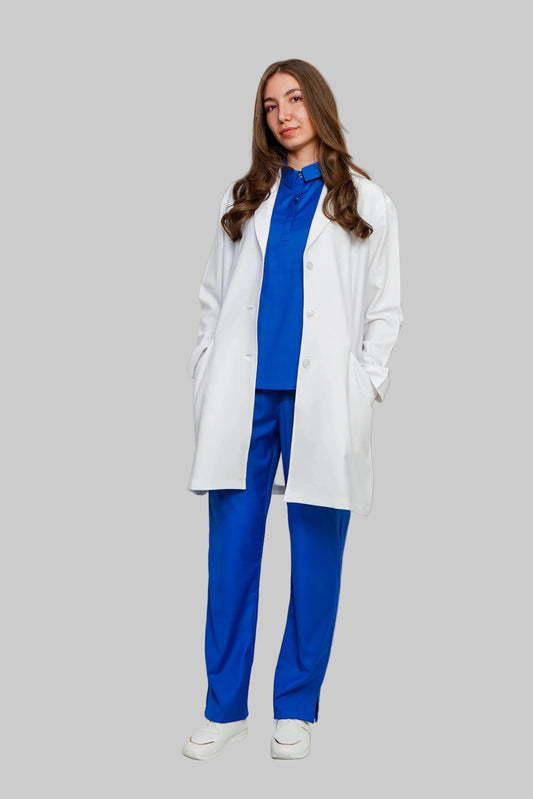 Woman wearing a white coat over a blue outfit on a plain background