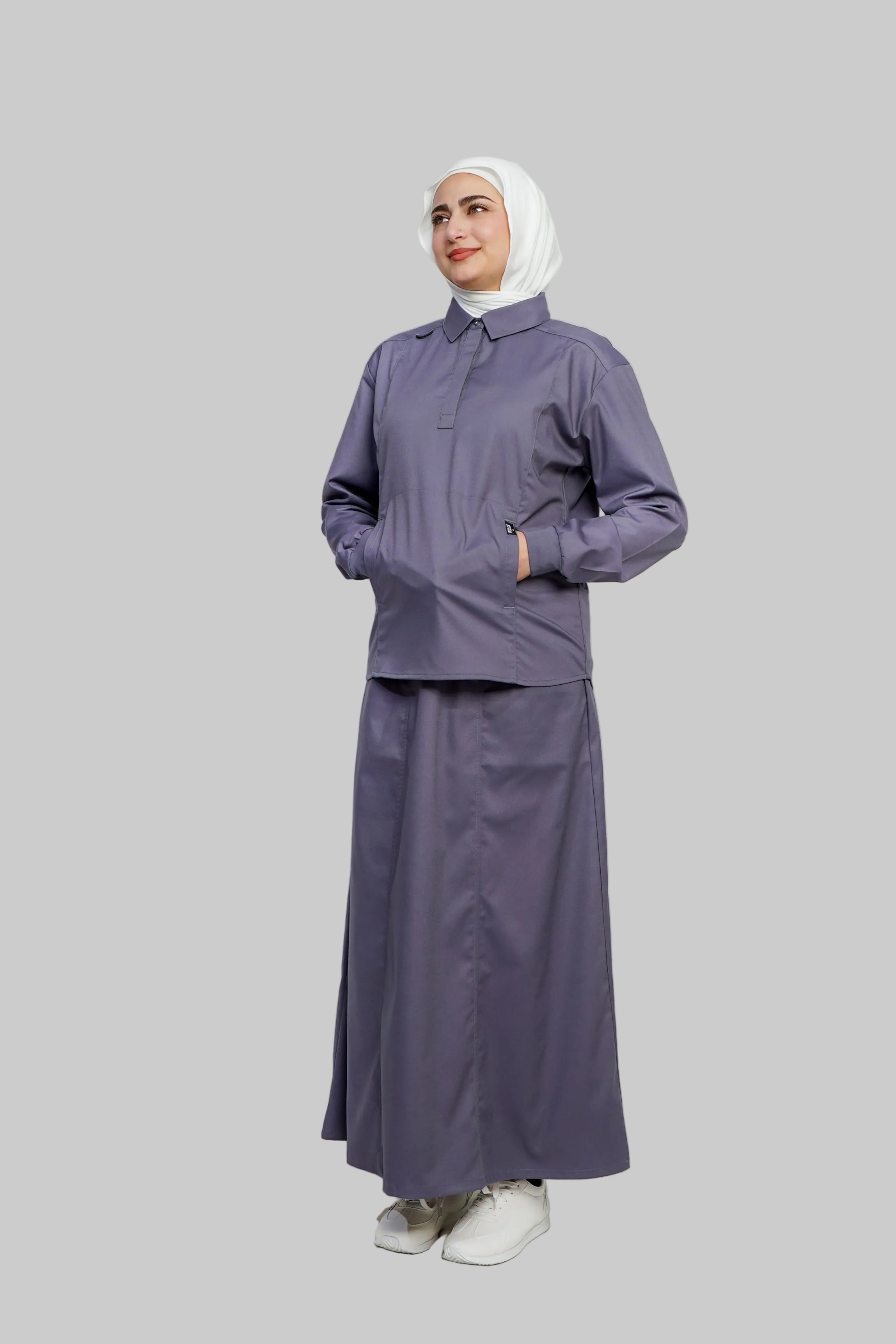 Woman wearing a gray outfit with a hijab on a white background