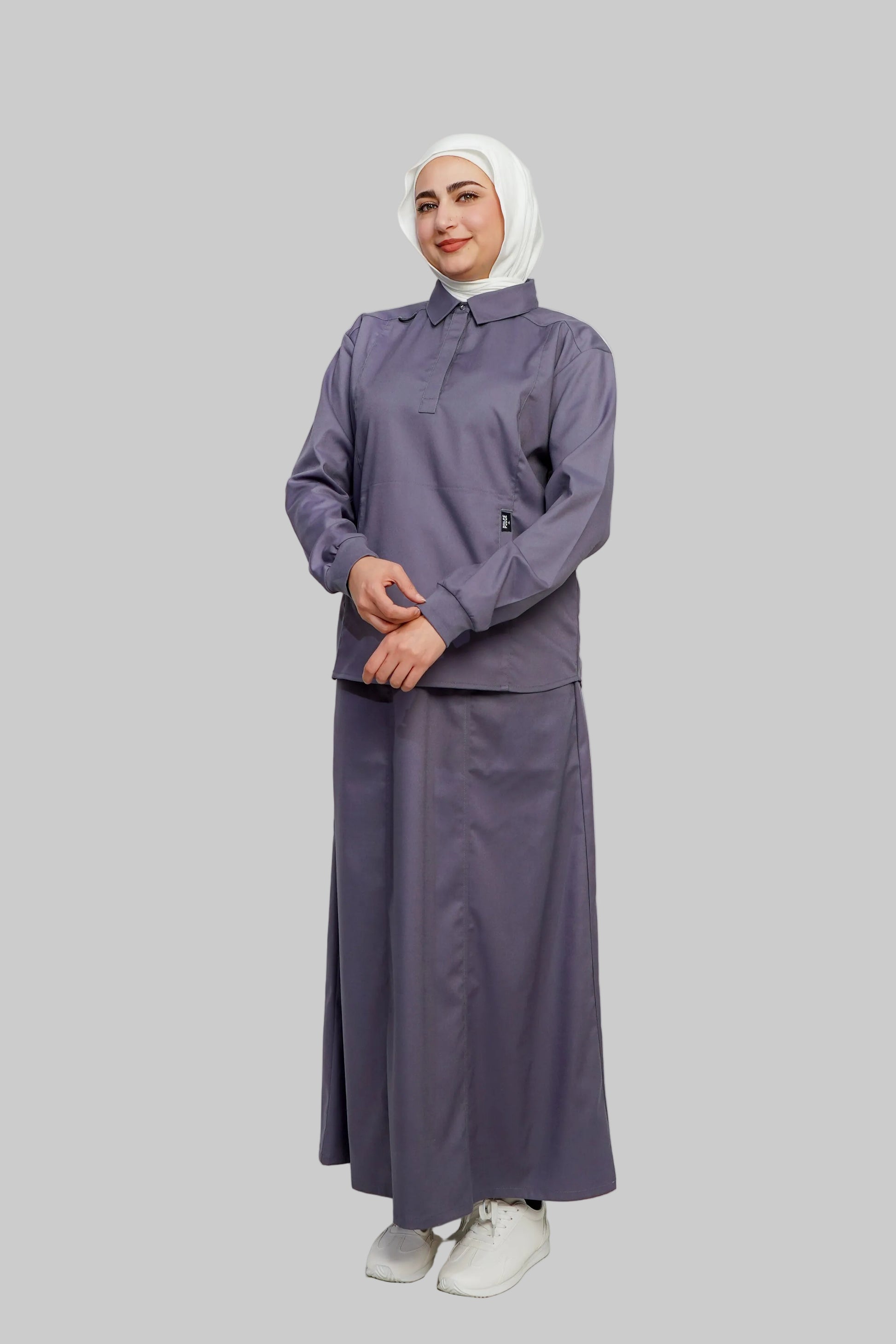Woman wearing a gray outfit with a hijab on a white background