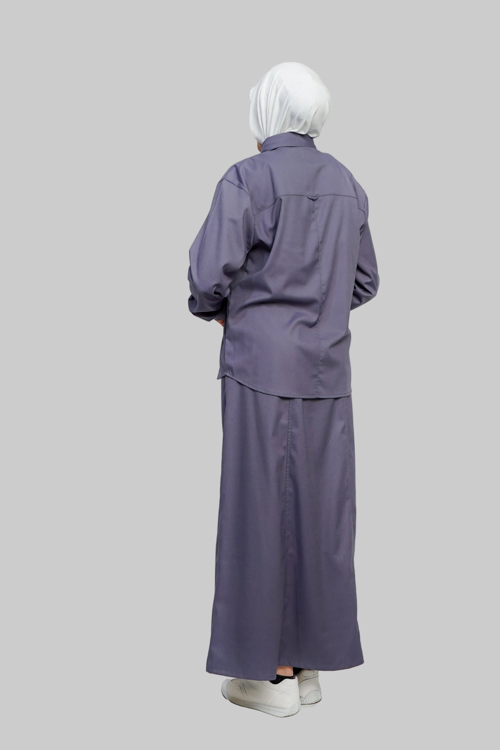 Person wearing a long-sleeve purple outfit with a matching headscarf on a white background