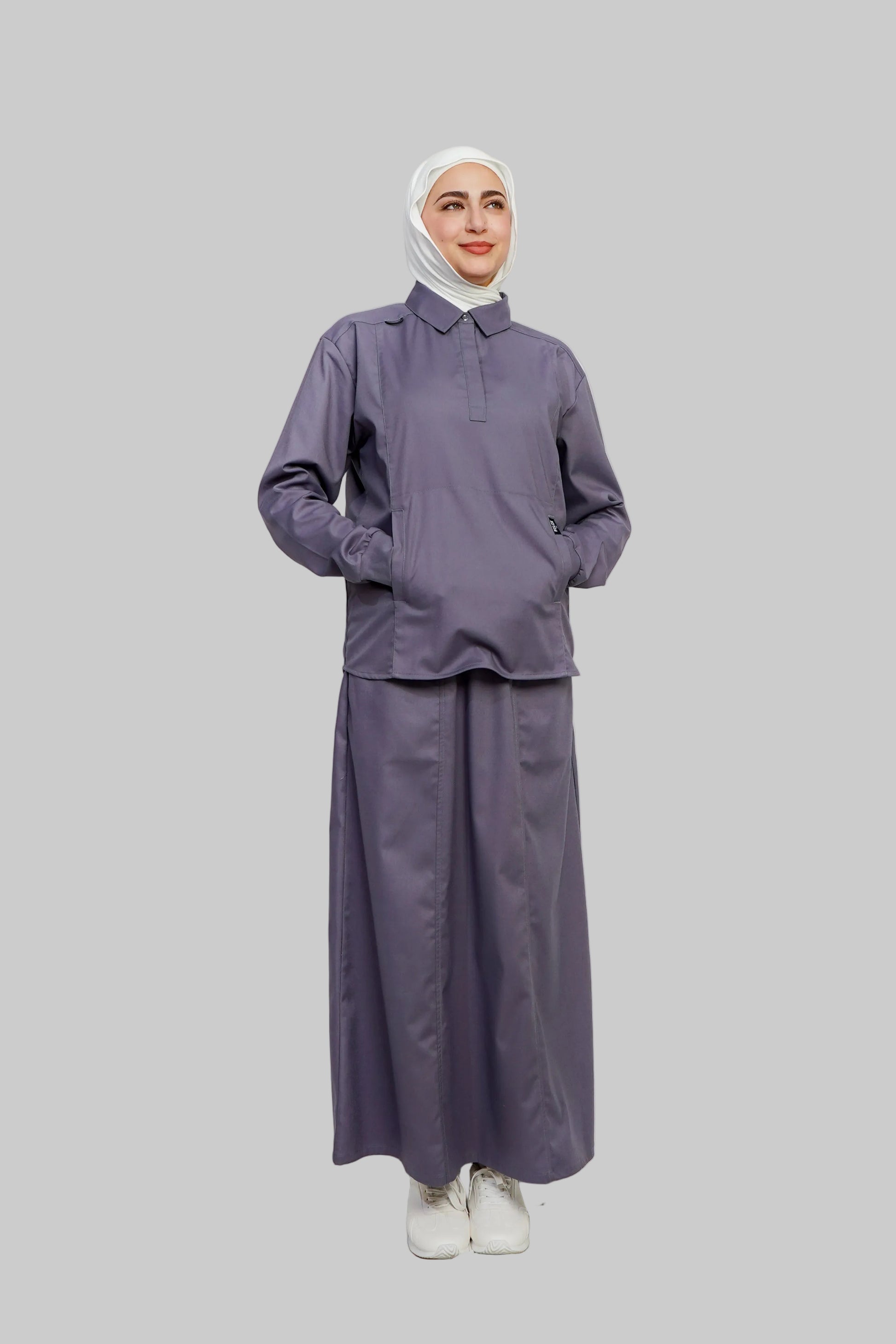 Person wearing a matching purple outfit with a hijab on a white background