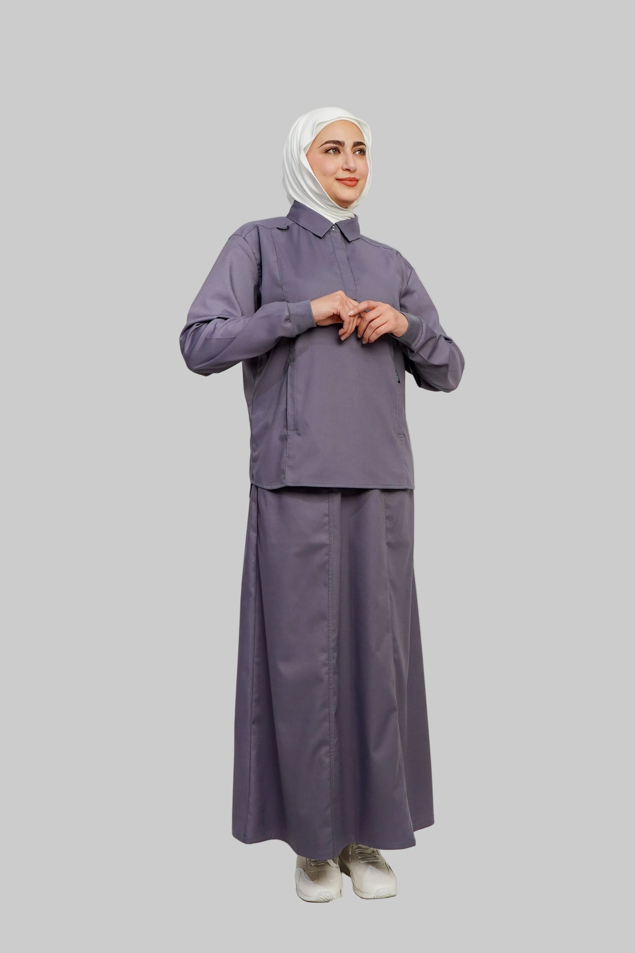 Woman wearing a matching purple outfit with a hijab on a white background