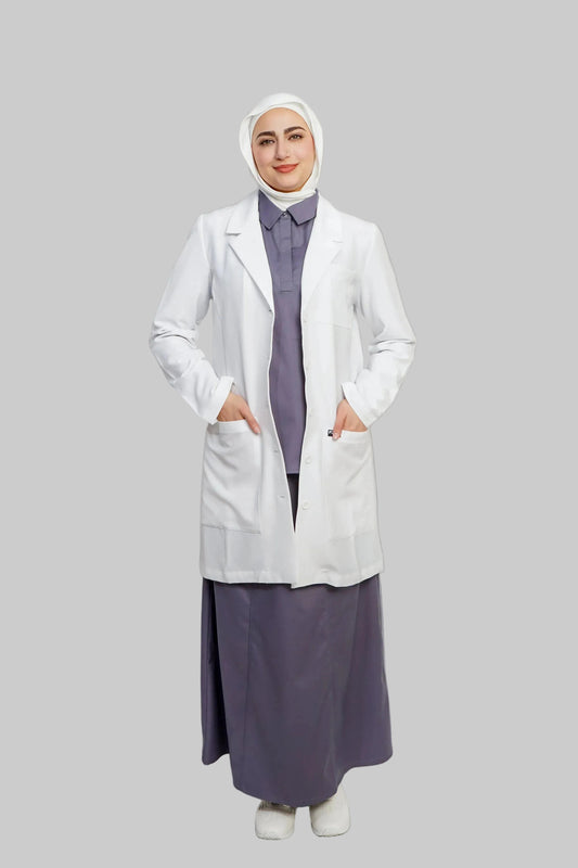 Person wearing a white lab coat over a long purple dress on a light gray background