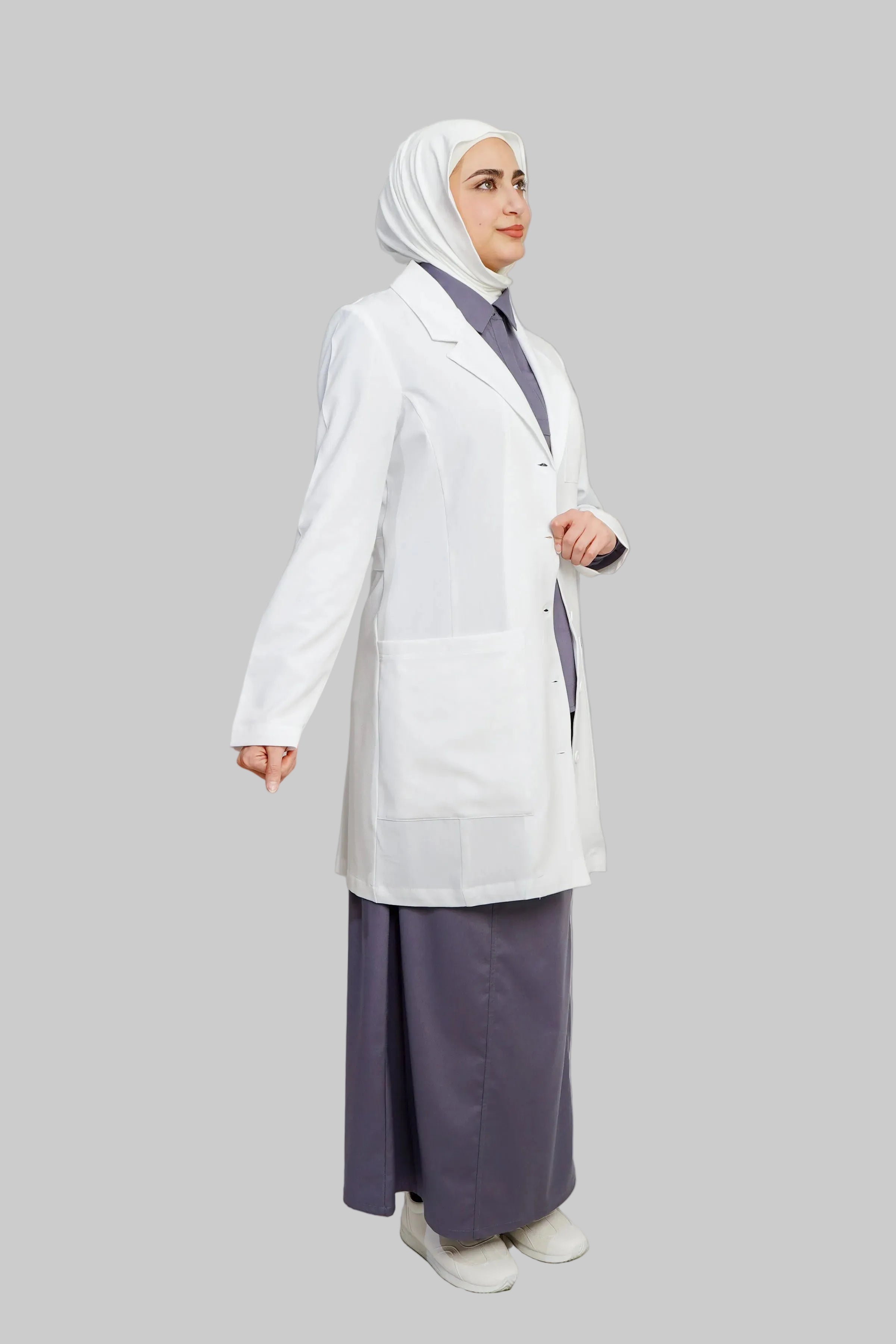 Person wearing a white lab coat and purple outfit on a plain background