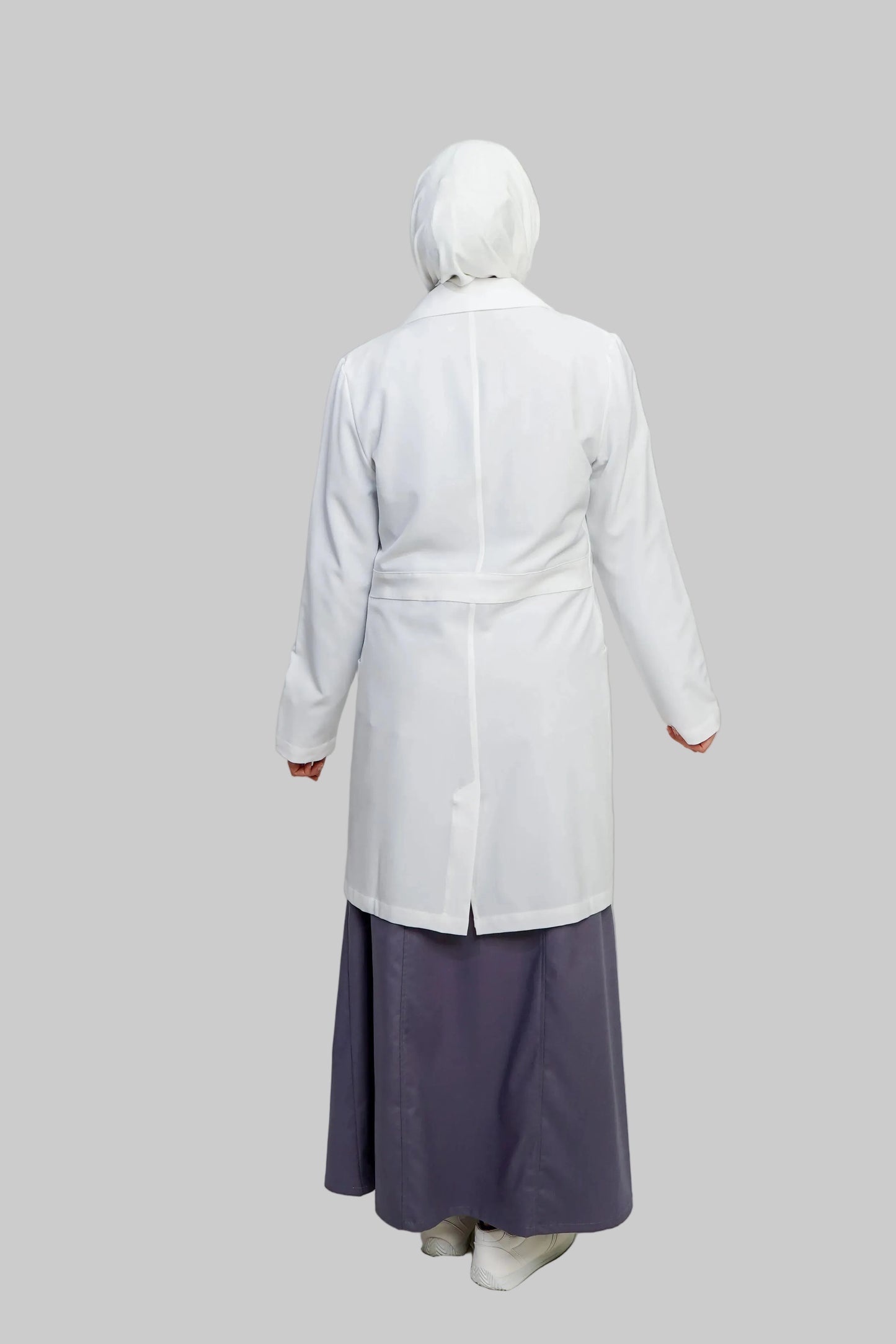 Person wearing a white coat and purple skirt on a plain background