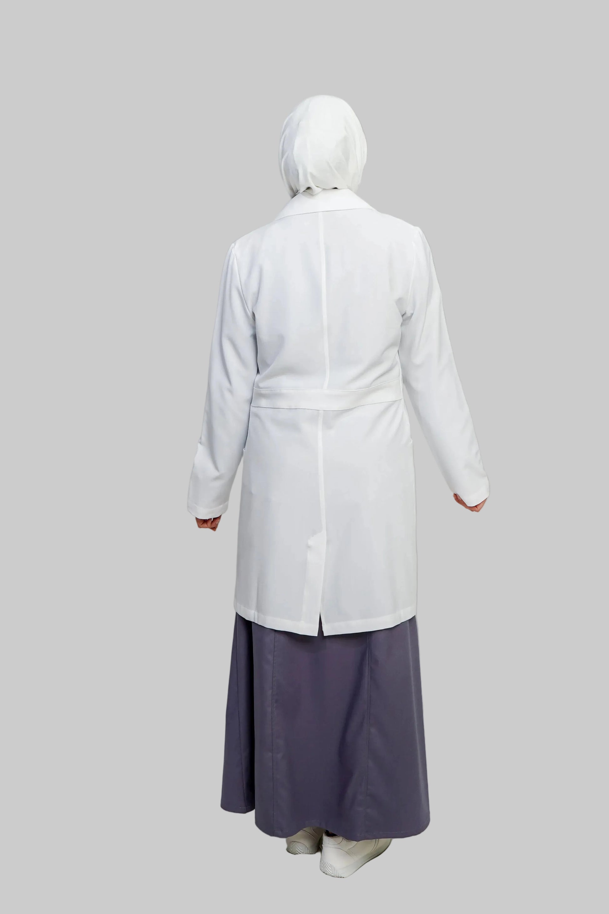 Person wearing a white coat and purple skirt on a plain background
