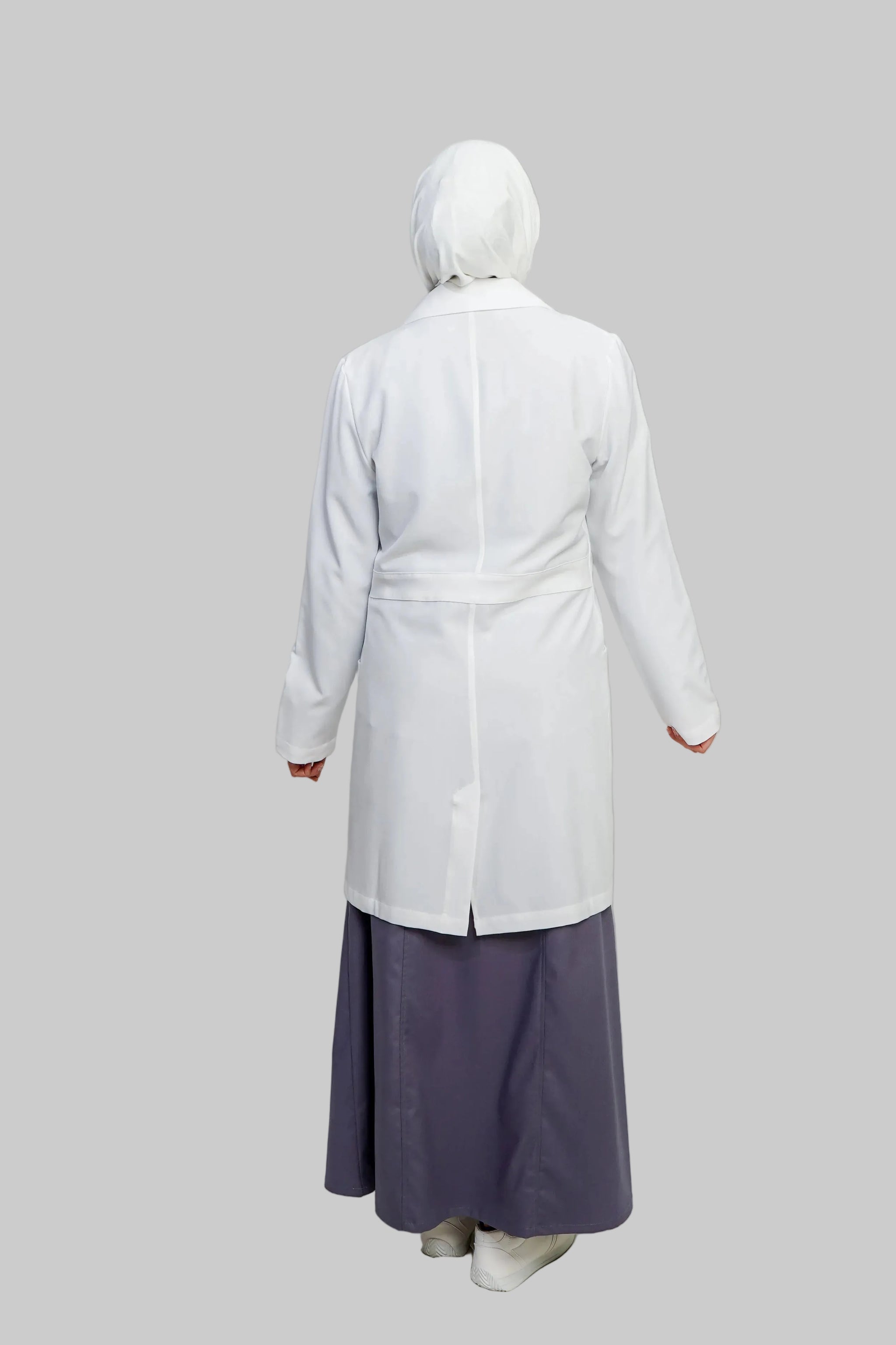 Person wearing a white coat and purple skirt on a plain background