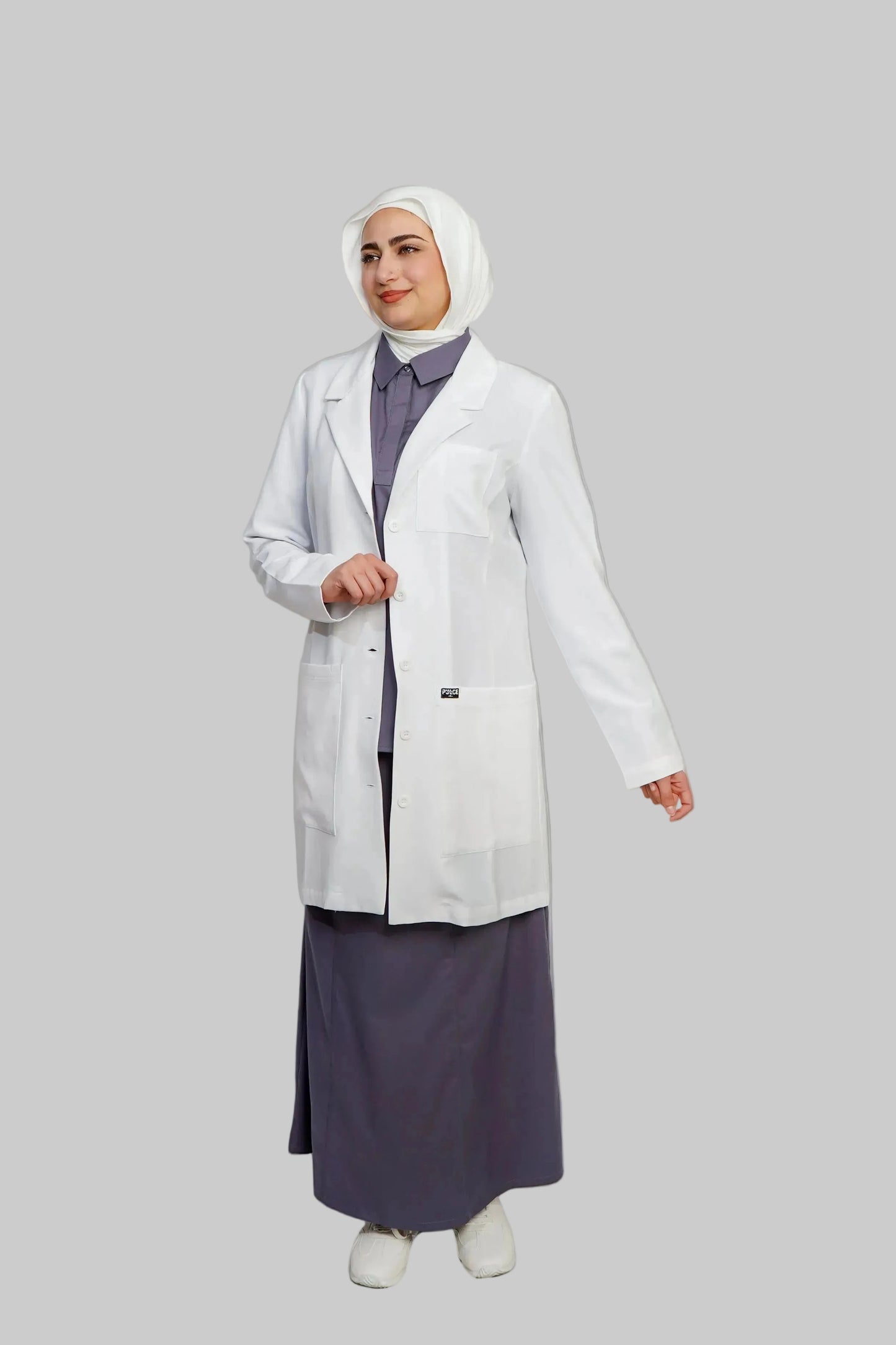 Person wearing a white lab coat over a dark outfit on a plain background