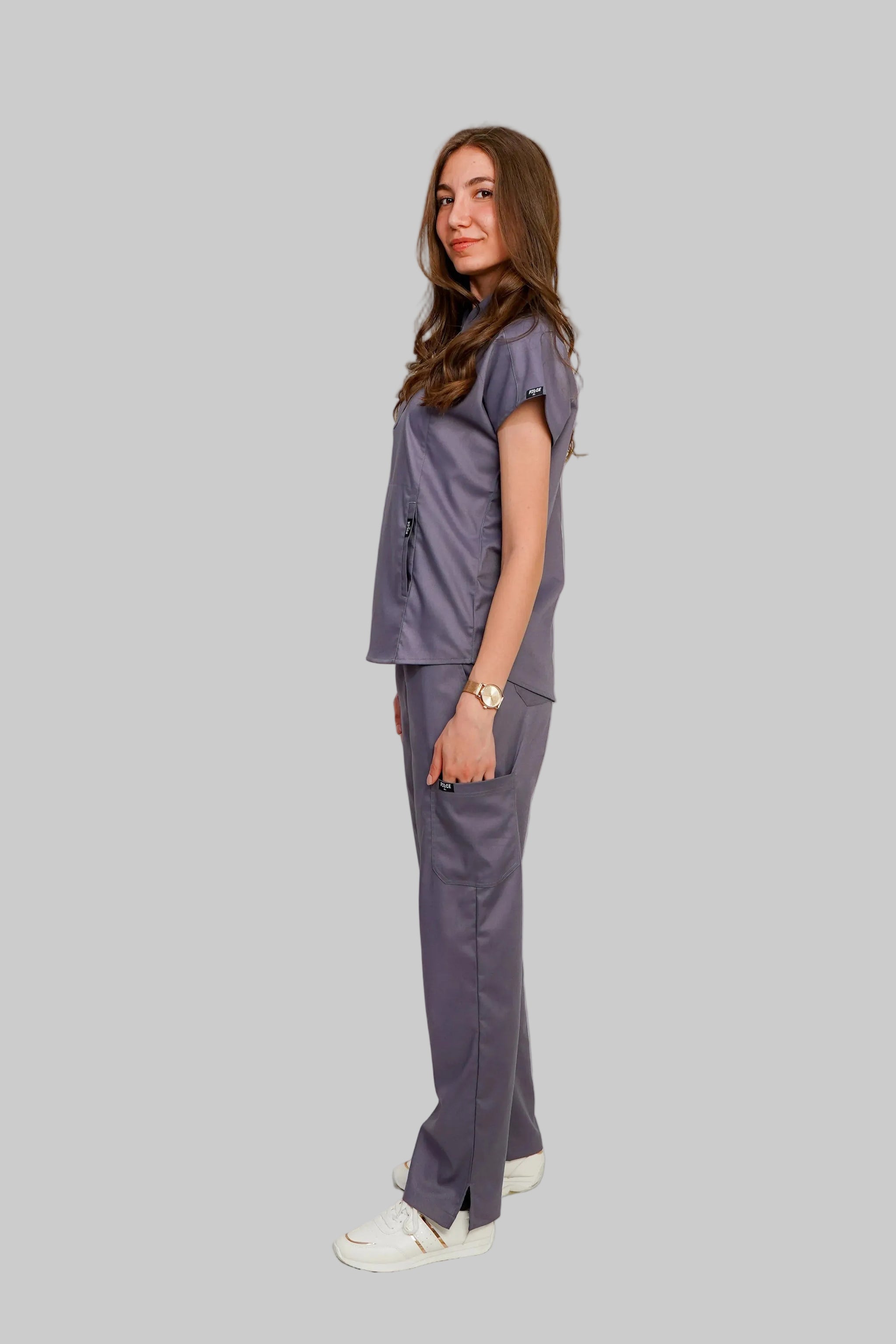 Woman wearing a gray scrub set on a white background