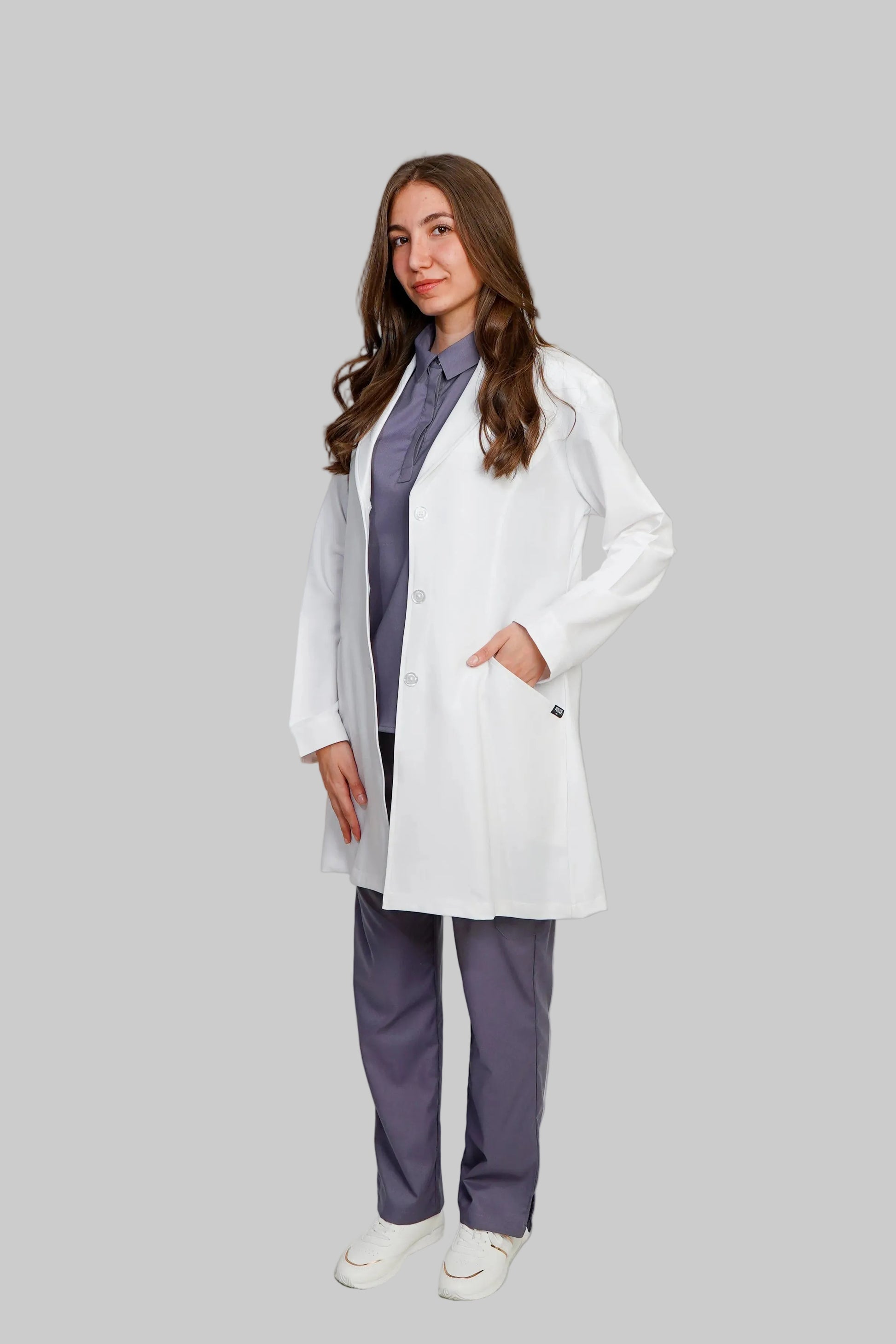 Person wearing a white lab coat over a purple outfit on a light gray background