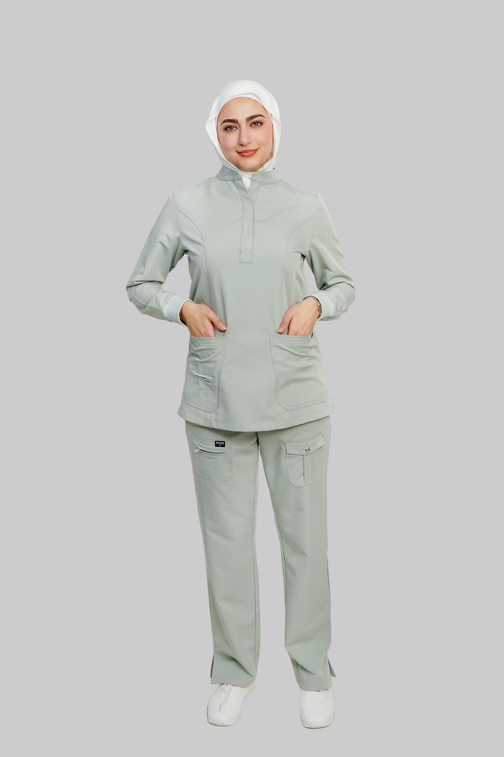 Person wearing a light gray medical uniform on a white background
