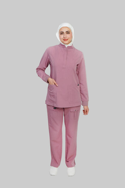 Person wearing a pink medical scrub set with a white hijab on a light gray background