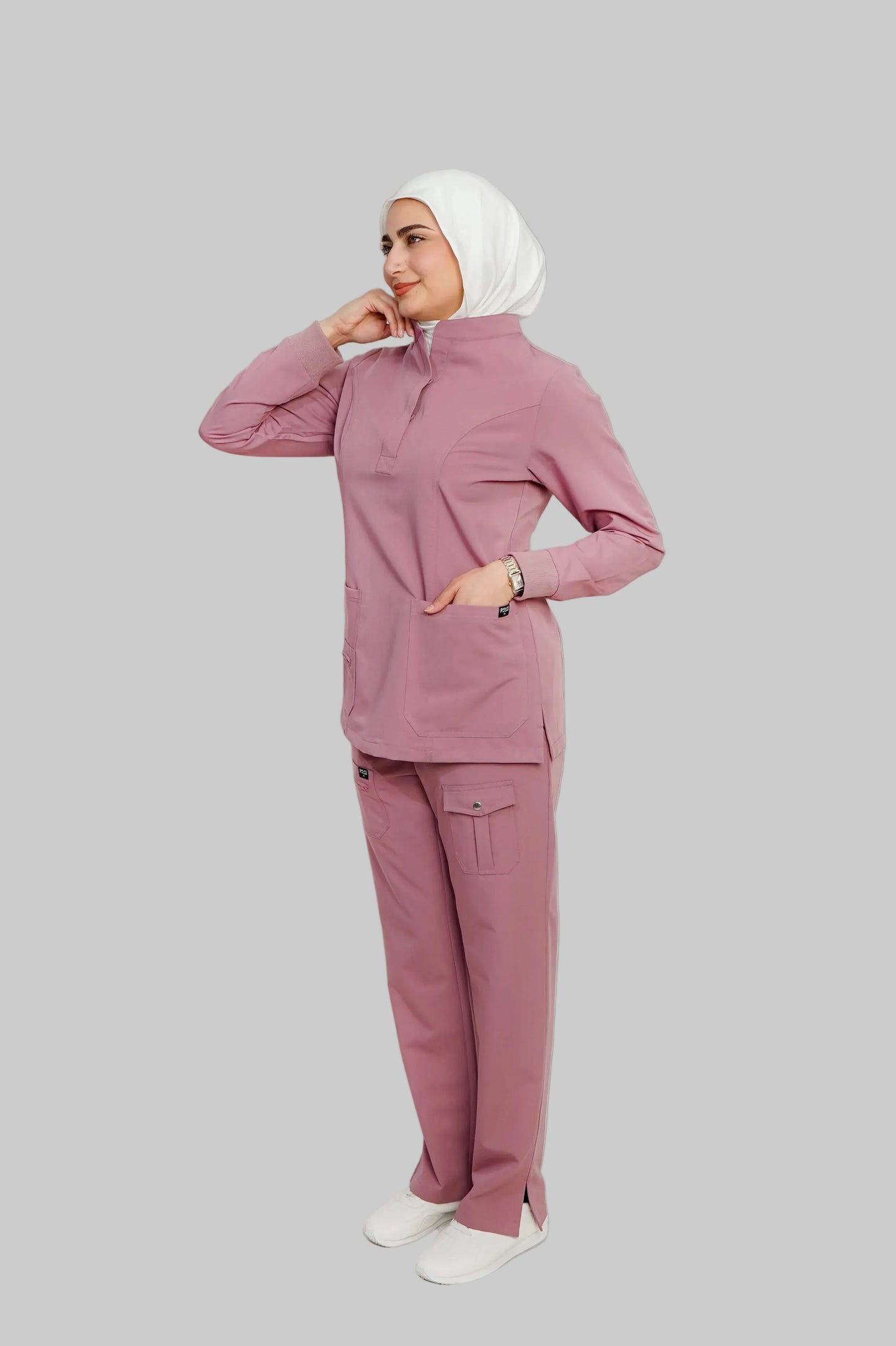 Woman wearing a pink outfit with a hijab on a white background